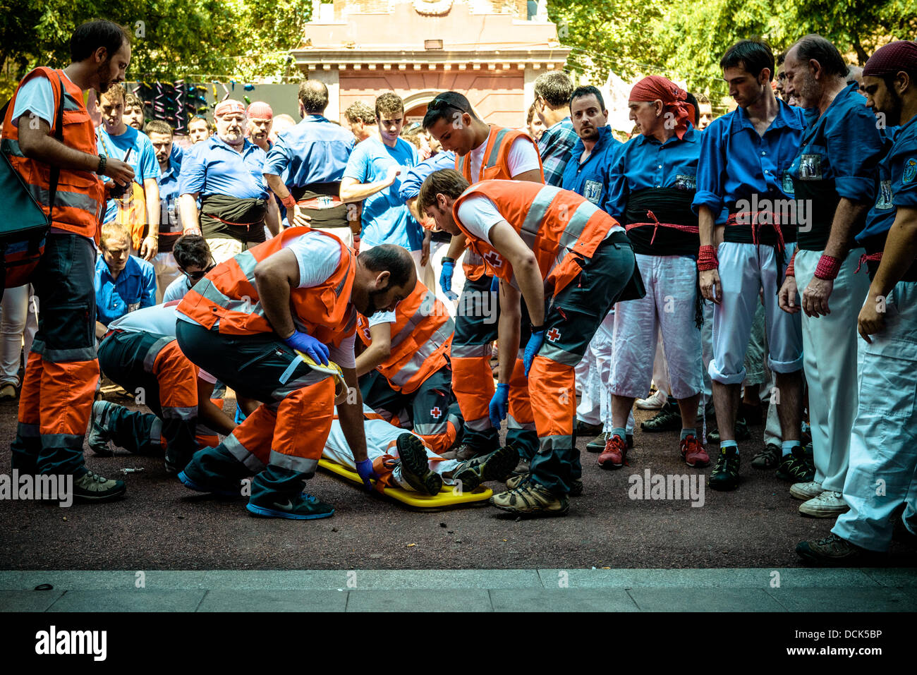 Barcelone, Espagne. Août 18, 2013. Août 18th, 2013. Barcelone, Espagne : les médecins et ambulanciers de donner les premiers soins à un membre de l'Castellers de la Vila de Gracia qui a été gravement blessé tandis que le tour de l'homme est effondré, comme ils démontée après avoir réussi à construire un '5 de 8' © matthi/Alamy Live News Banque D'Images