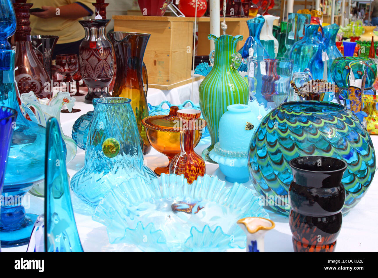 Collection de verrerie vintage coloré est affichée sur un tableau vente à un marché aux puces d'Antiquités Banque D'Images