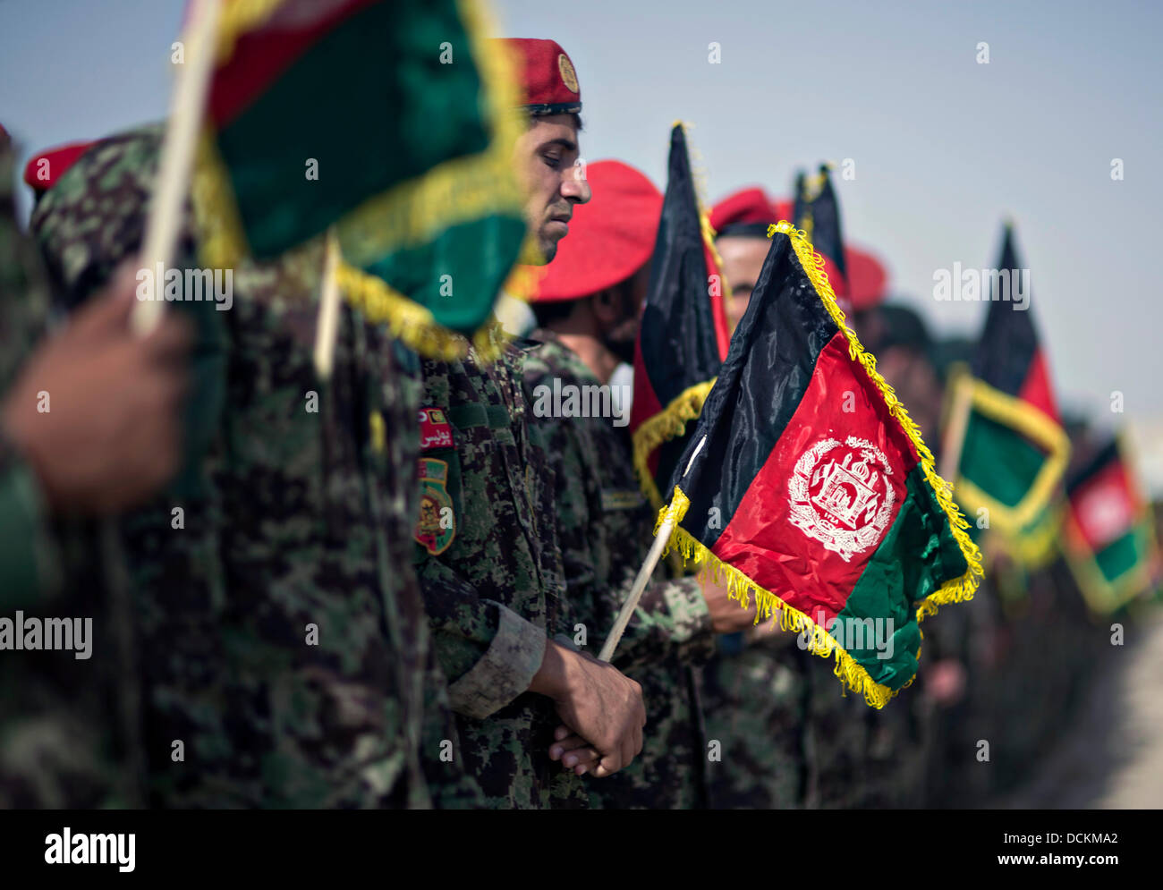Stand de l'Armée nationale afghane en formation avec les drapeaux pendant l'hymne national lors d'une célébration marquant la fête de l'indépendance de l'Afghanistan, le 19 août 2013 au Camp Shorabak, province de Helmand, en Afghanistan. Banque D'Images
