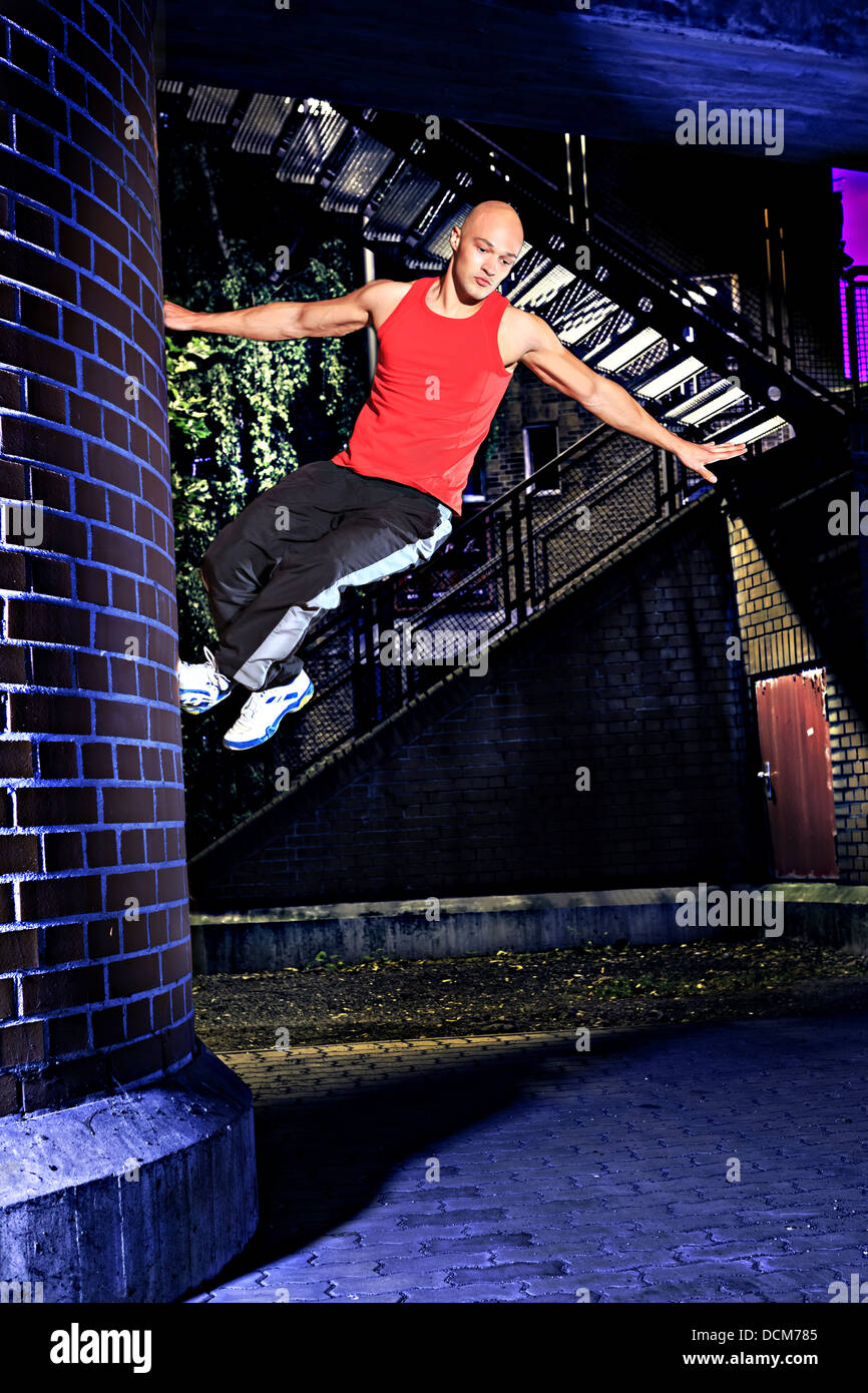 Un jeune homme à la formation parkour dans la ville Banque D'Images