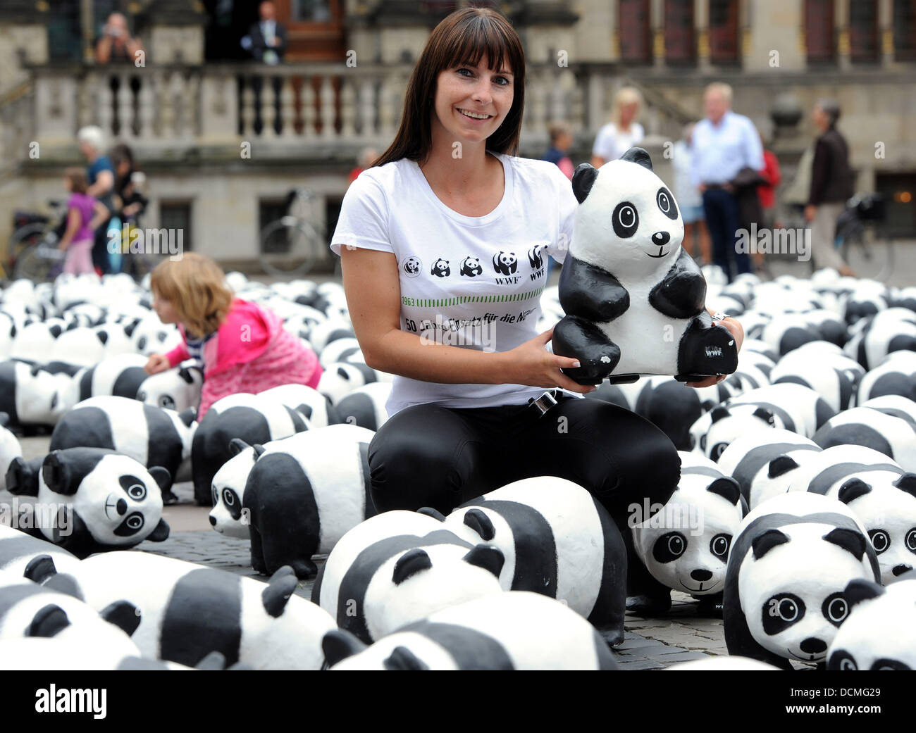 Brême, Allemagne. 20e Août 2013. Organisation de la protection de l'environnement WWF Allemagne présente 1 600 pandas en papier mâché sur la Marktplatz square à Brême, Allemagne, 20 août 2013. Le WWF employé Denise Freisewinkel est titulaire d'un des chiffres produits panda et peint à la main en Thaïlande. L'environnement WWF Organisation célèbre son 50e anniversaire en soulignant qu'il n'y a que 1 600 pandas dans le monde gauche. Photo : INGO WAGNER/dpa/Alamy Live News Banque D'Images