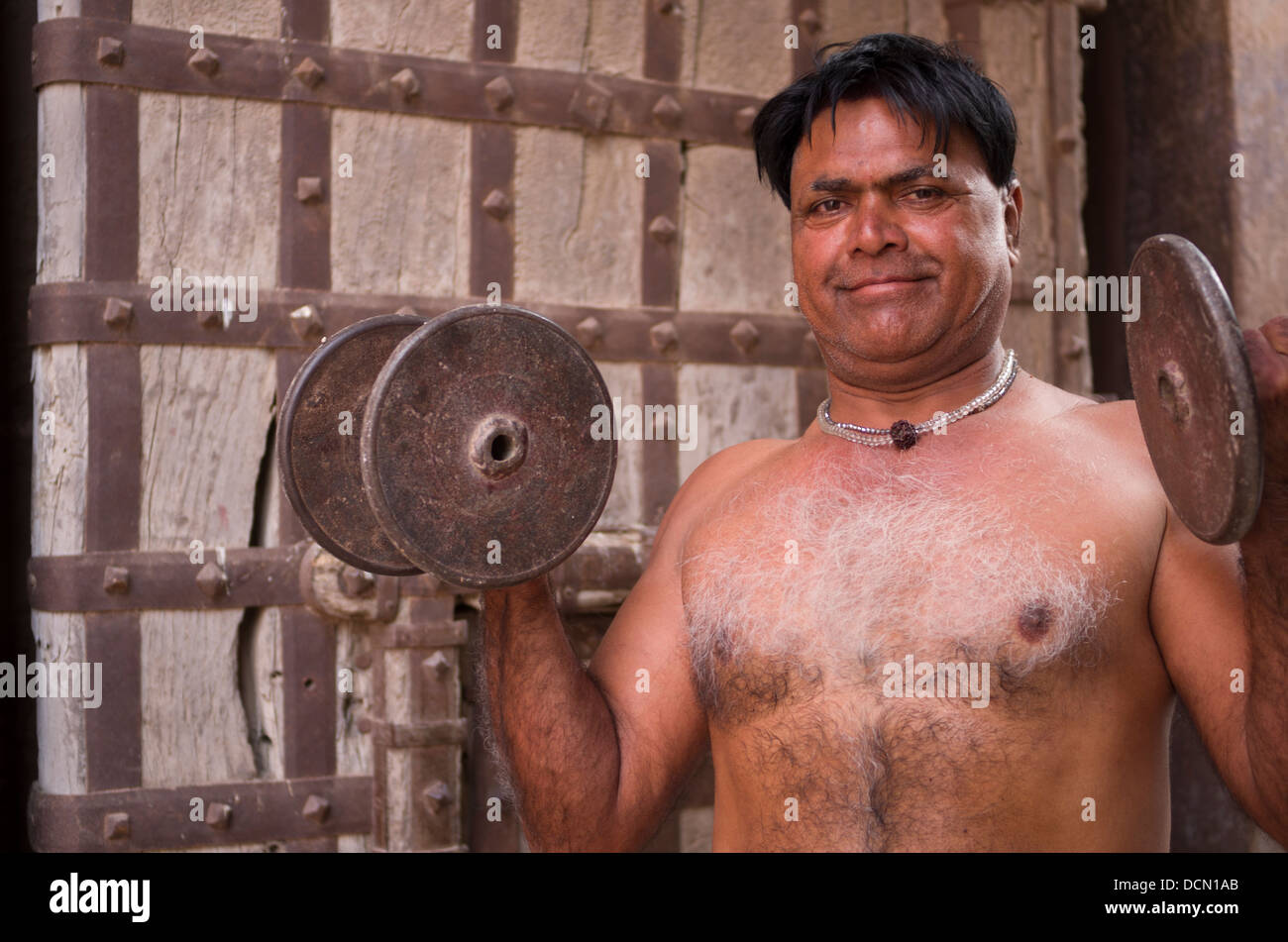 L'homme indien avec formation à l'extérieur des portes de dumbells Meherangarh Fort - Jodhpur, Rajashtan, Inde Banque D'Images