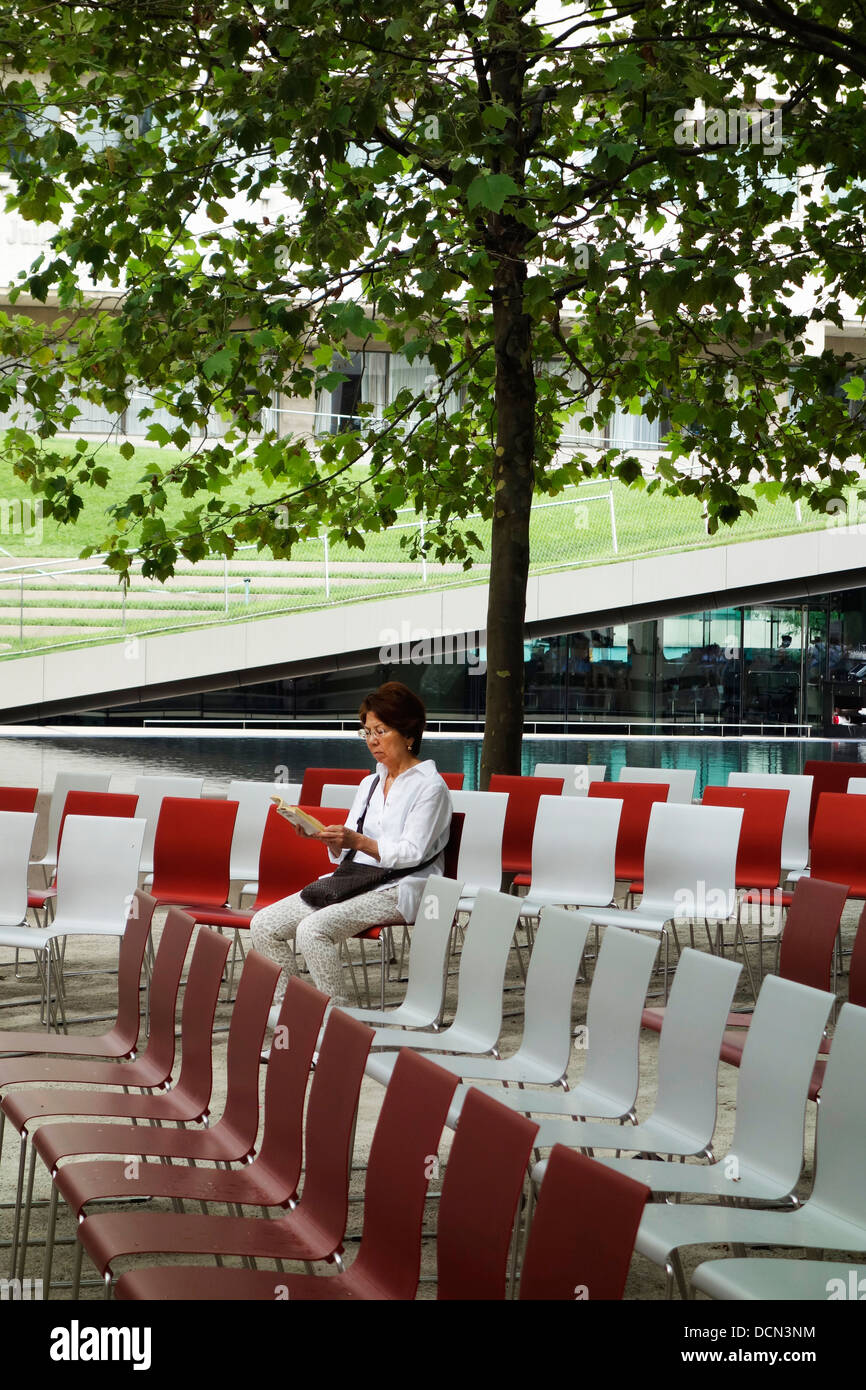 Femme assise sur des chaises à l'extérieur Banque D'Images