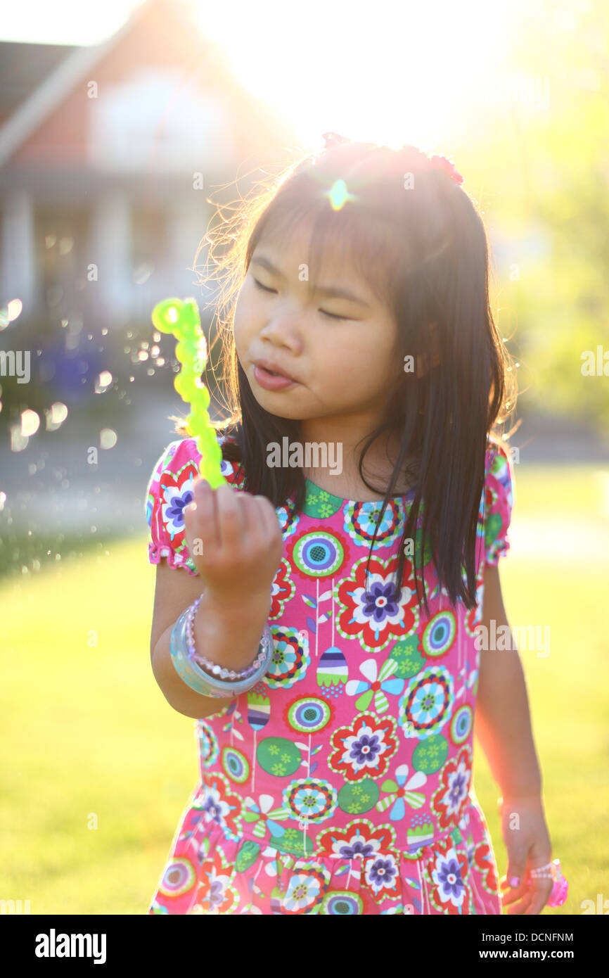 Young Girl blowing bubbles outdoors en été Banque D'Images