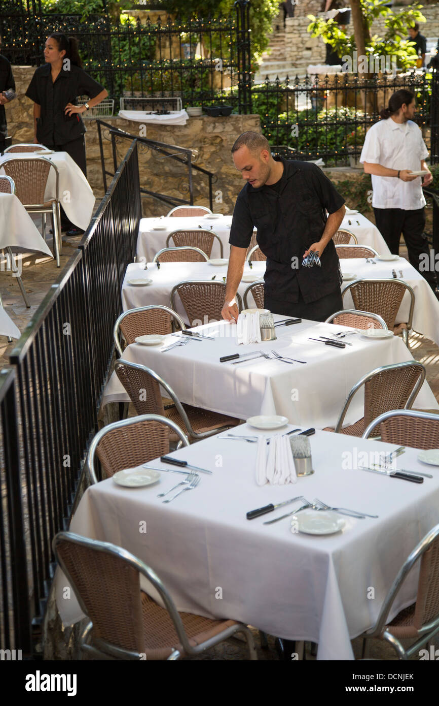 San Antonio, Texas - Un serveur définit les tables pour le dîner dans un restaurant sur le Riverwalk. Banque D'Images