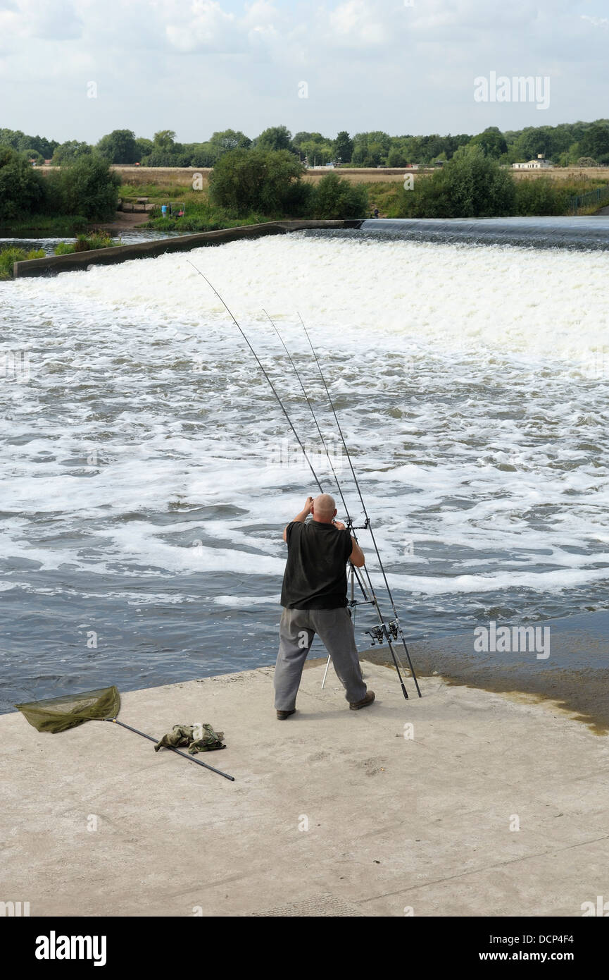 Un homme s'adapter ses cannes à pêche Beeston weir Nottingham England uk Banque D'Images
