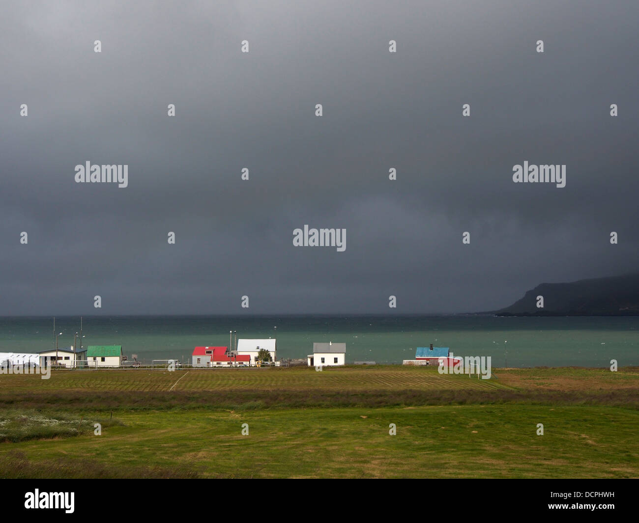 Pluie nuages sombres plus de maisons, Bakkagerði Borgarfjörður Eystri, Islande, Banque D'Images