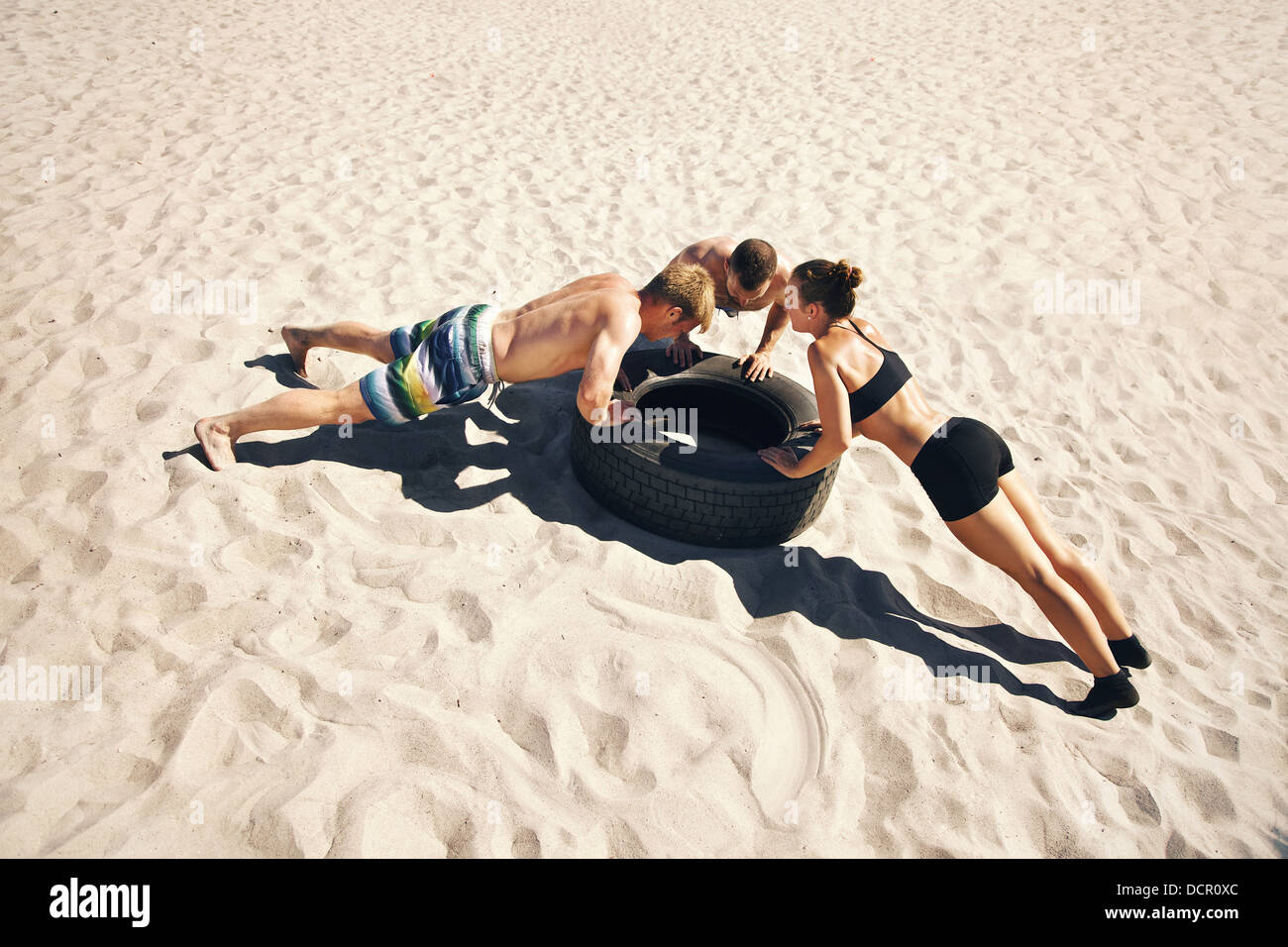 Un groupe de faire crossfitters push-ups sur le pneu Banque D'Images