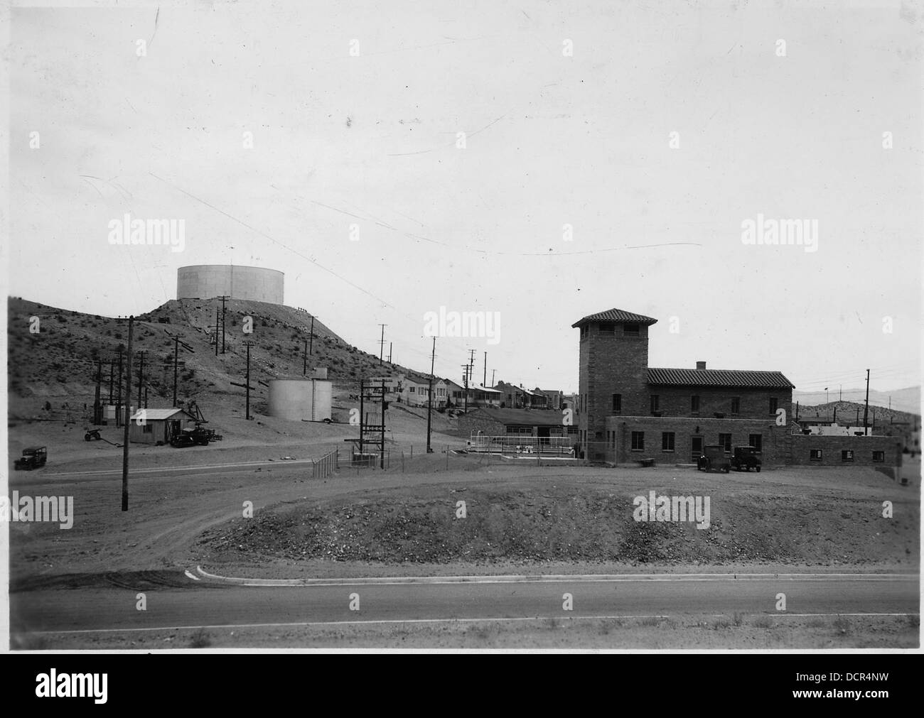 Cette photographie montre les principales unités de l’approvisionnement en eau de Boulder City, avec une vue de l’ouest mettant en évidence un réservoir de stockage de 2 000 000 gallons sur une colline. Il démontre l'ampleur de l'infrastructure de l'eau nécessaire pour répondre aux besoins de la ville. Banque D'Images Cette photographie montre les principales unités de l’approvisionnement en eau de Boulder City, avec une vue de l’ouest mettant en évidence un réservoir de stockage de 2 000 000 gallons sur une colline. Il démontre l'ampleur de l'infrastructure de l'eau nécessaire pour répondre aux besoins de la ville. Banque D'Images
