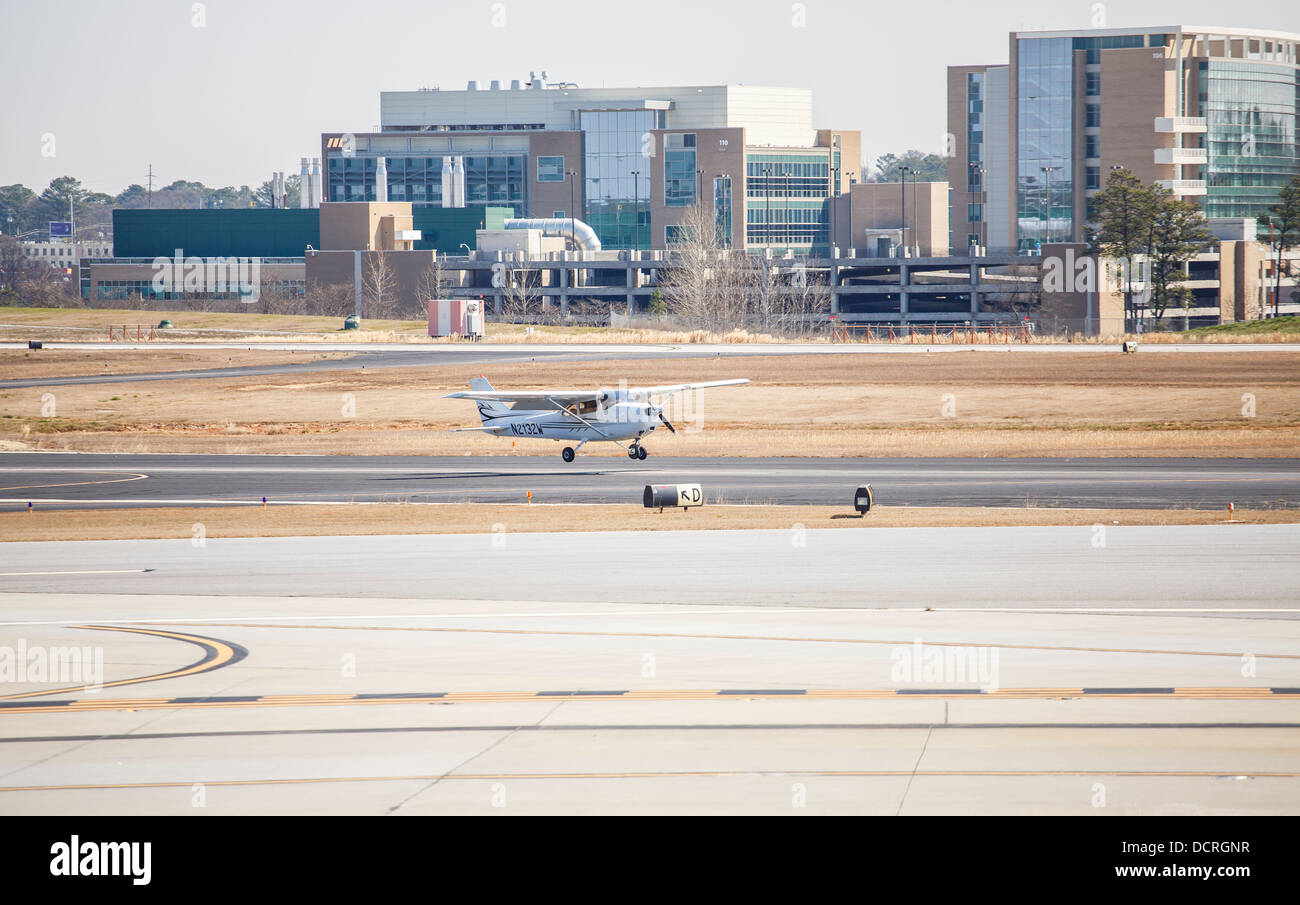 Un seul avion hélice moteur Cessna 172 sur la piste d'un petit aéroport régional Banque D'Images Un seul avion hélice moteur Cessna 172 sur la piste d'un petit aéroport régional Banque D'Images