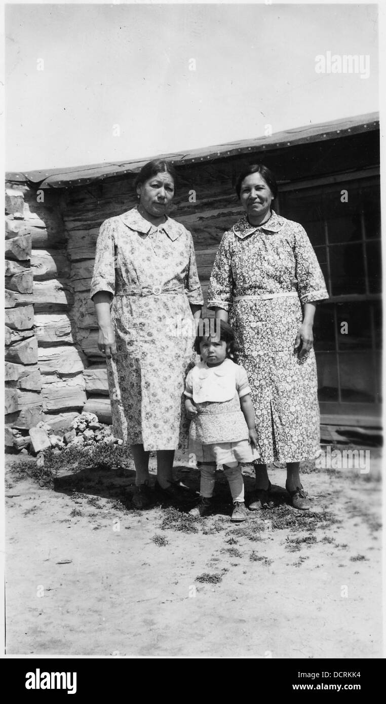 Angelique Fire Thunder, Lydia Blue Bird et un petit enfant posent devant une cabane, représentant le patrimoine amérindien et la vie communautaire dans la région. Banque D'Images Angelique Fire Thunder, Lydia Blue Bird et un petit enfant posent devant une cabane, représentant le patrimoine amérindien et la vie communautaire dans la région. Banque D'Images