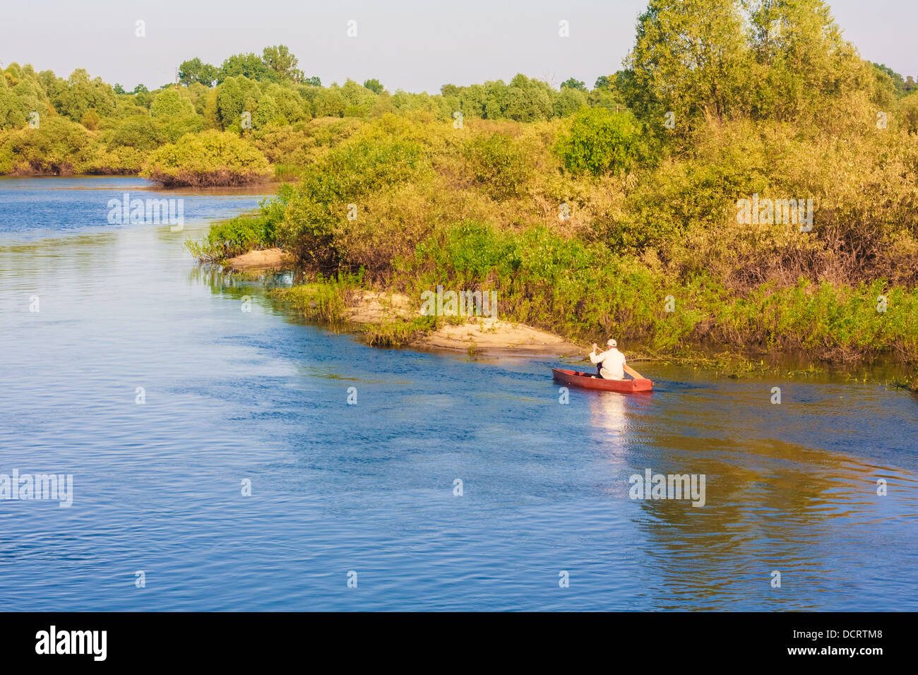 Vieil Homme Pêche hors d'un bateau à rames Banque D'Images