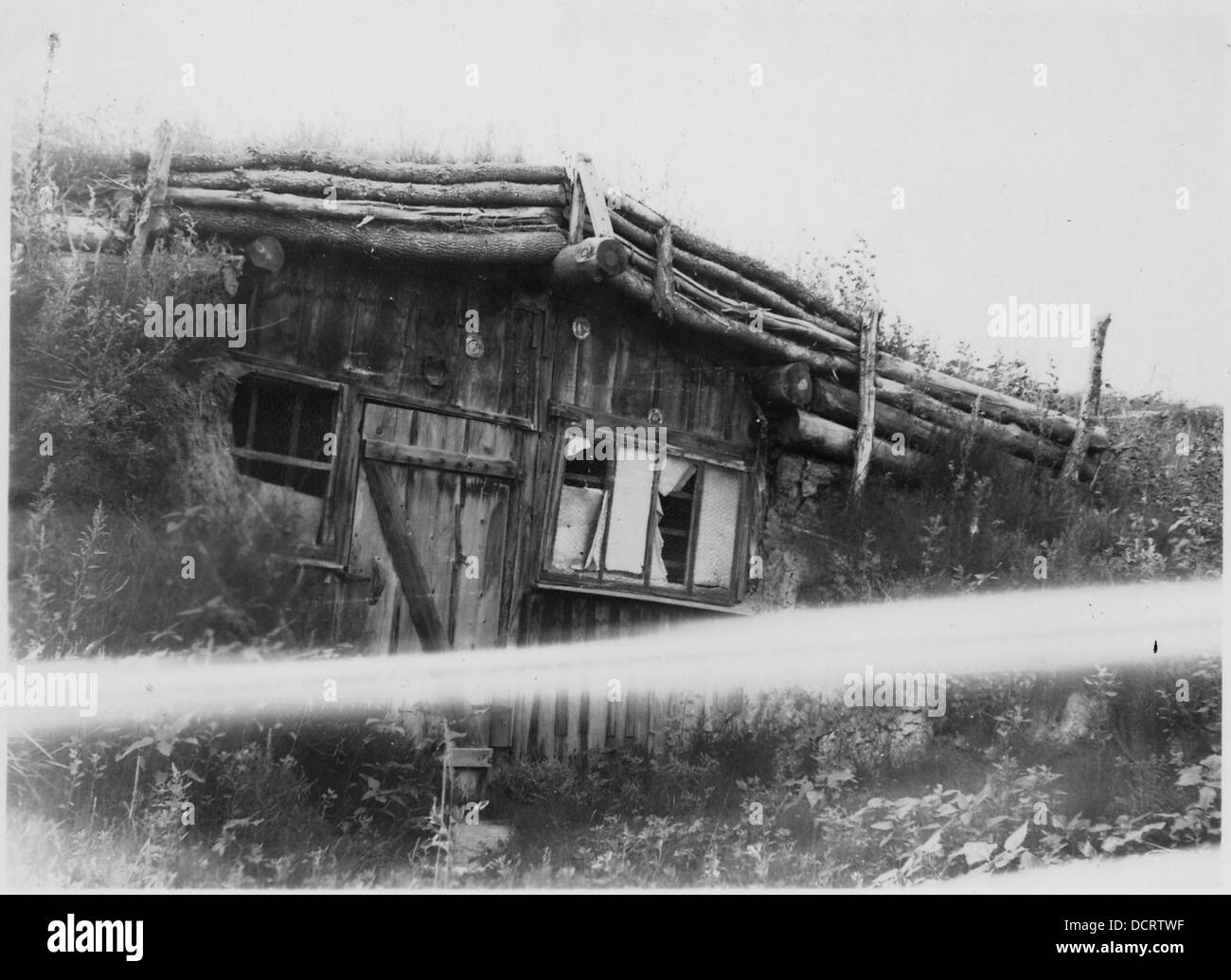 Cette image montre un atelier de forgeron avec des fenêtres cassées et un toit en gazon, reflétant les conditions difficiles d'un atelier rural d'une époque passée de l'histoire américaine. Banque D'Images