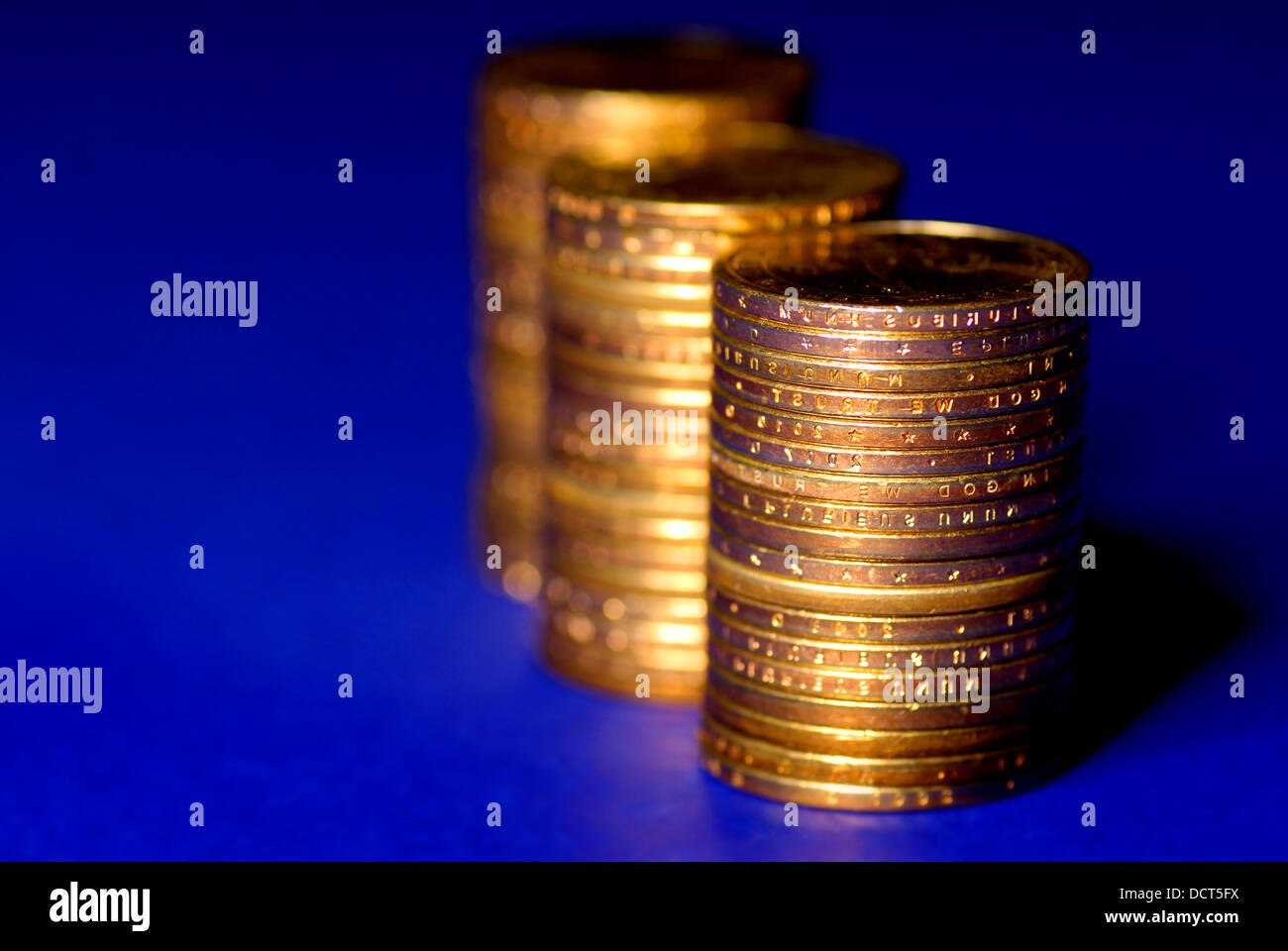 Plusieurs piles de pièces d'or sur fond bleu Banque D'Images