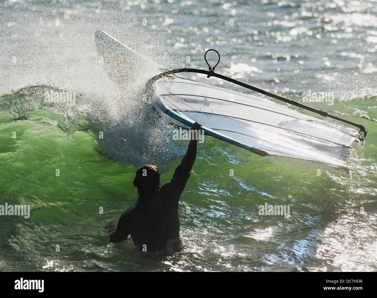 Un homme dans l'eau tenant sur sa planche à voile ; Tarifa, Cadix, Andalousie, Espagne Banque D'Images