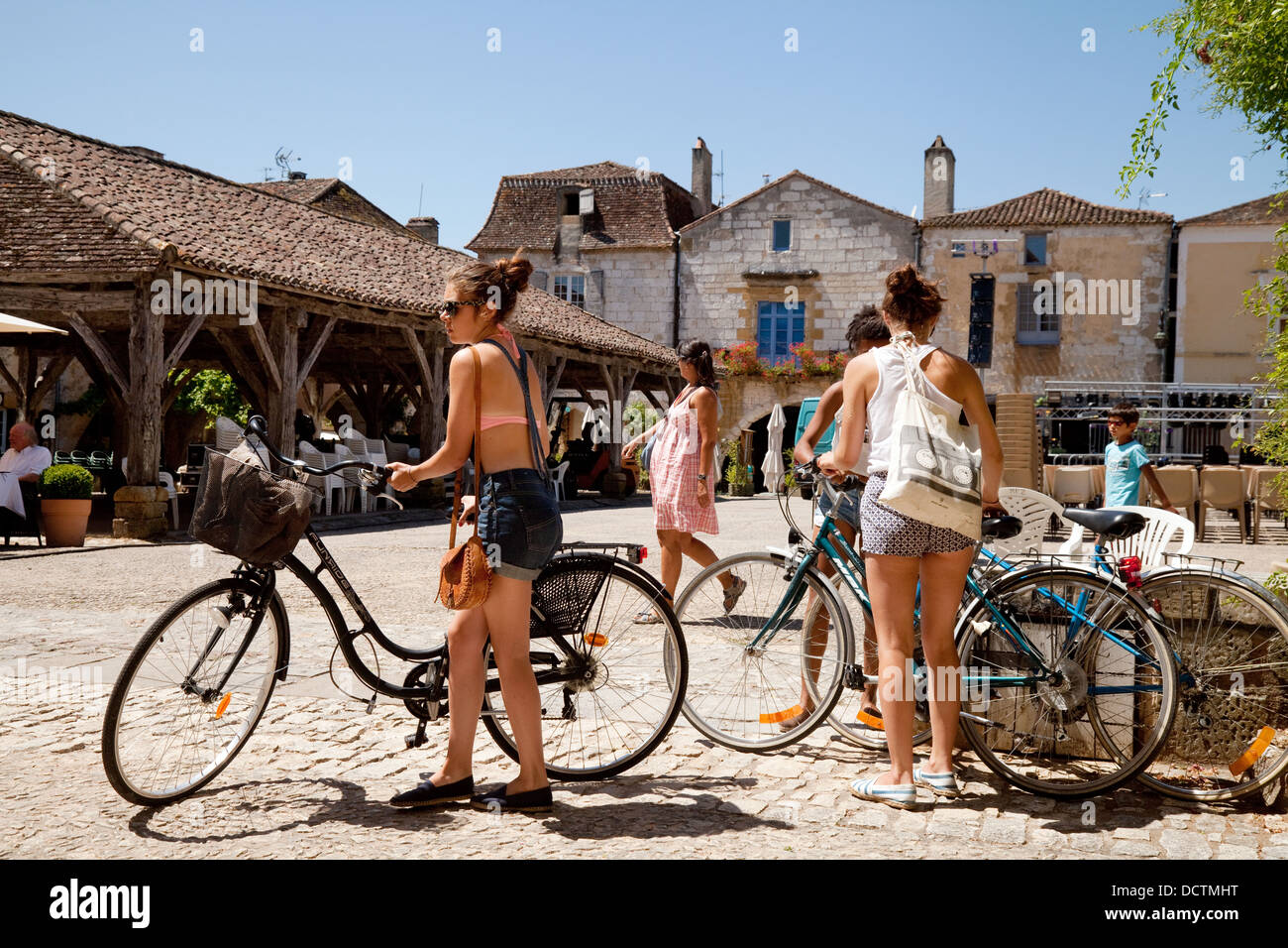Les adolescentes en vacances à vélo dans un village bastide de Monpazier, Dordogne, France, Europe Banque D'Images