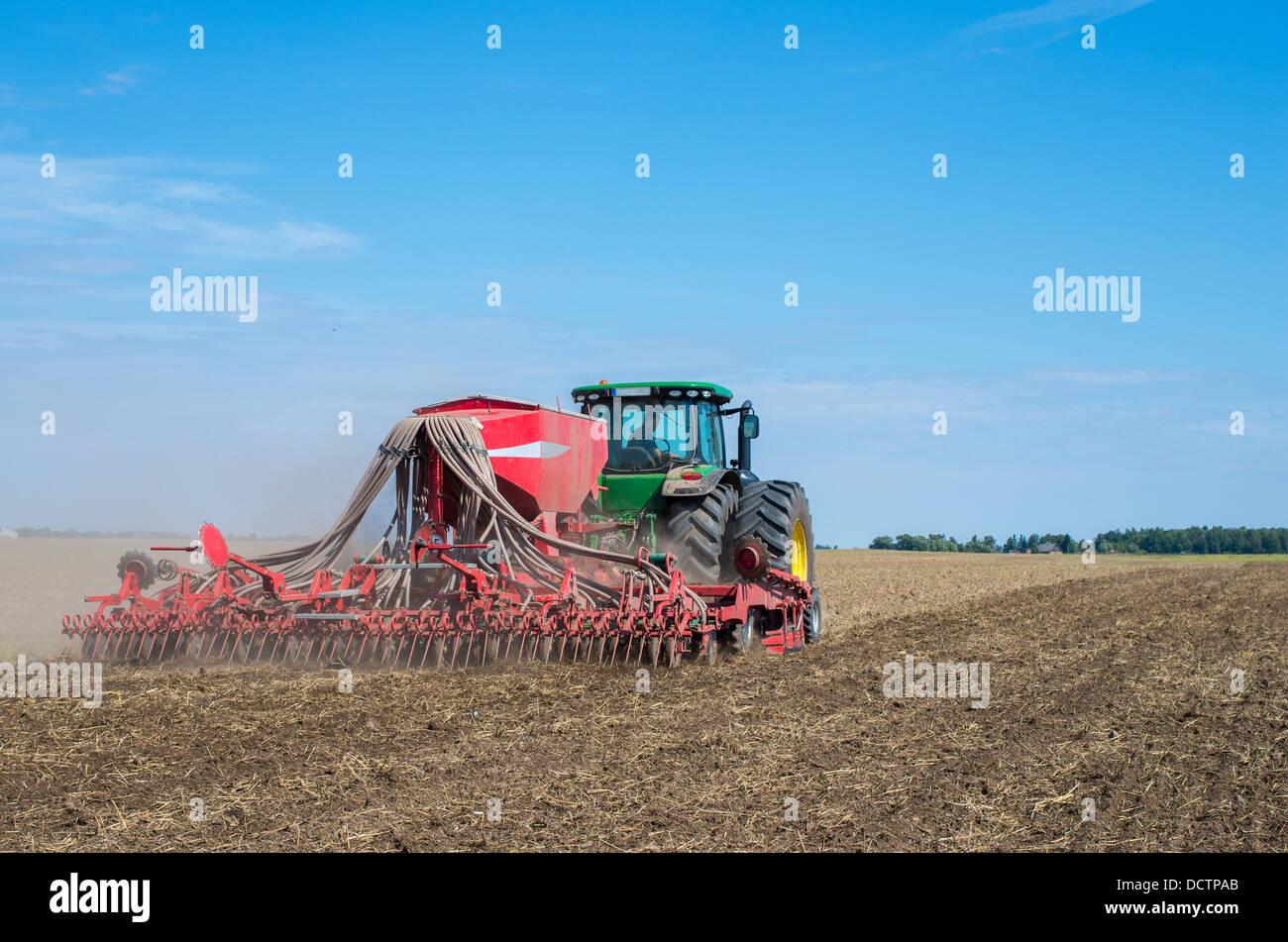 Tracteur agricole et de l'arrière du semoir travaillant dans un domaine Lituanien Banque D'Images