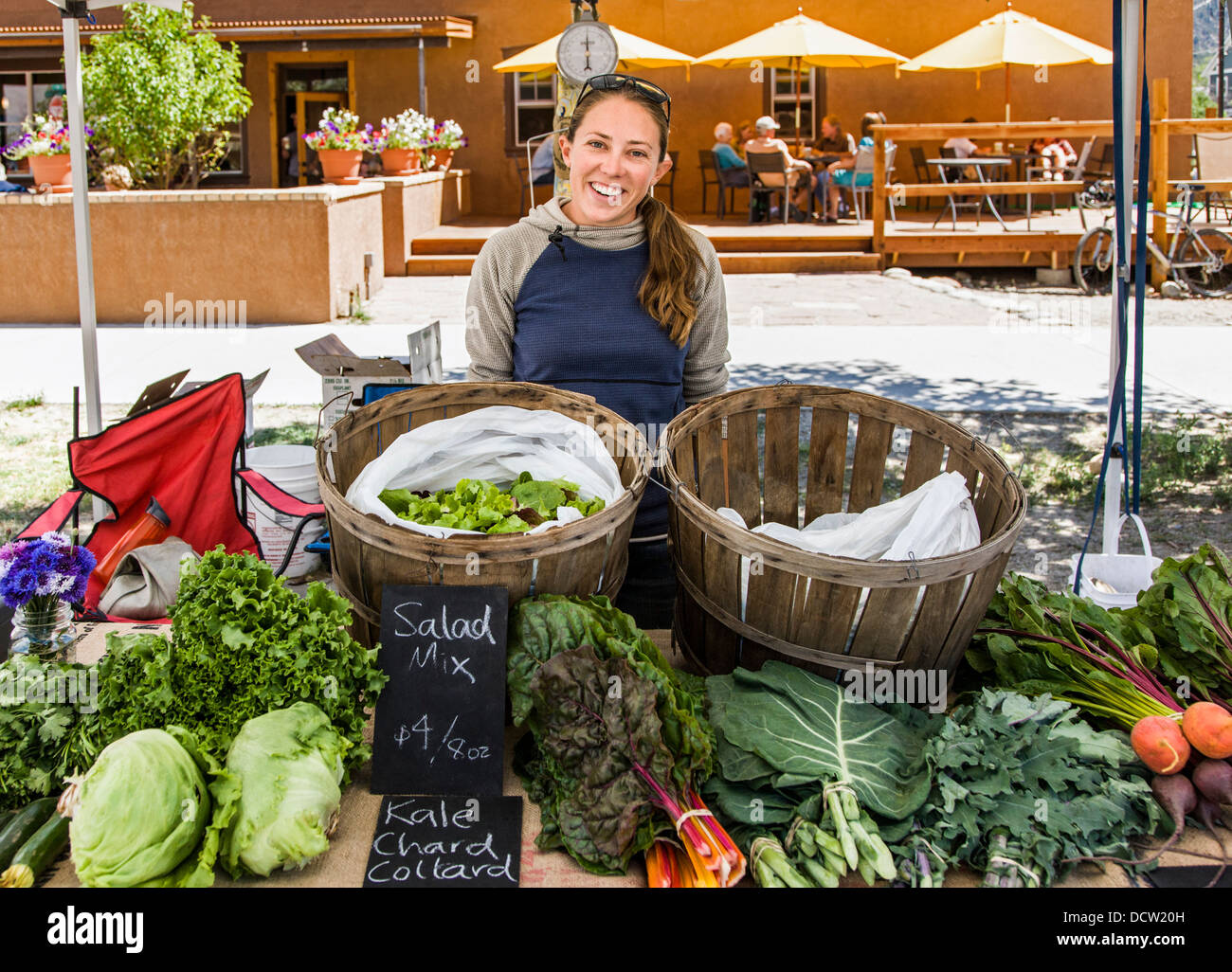 Jeune femme vendant des fruits et légumes à la Buena Vista Colorado farmer's market Banque D'Images