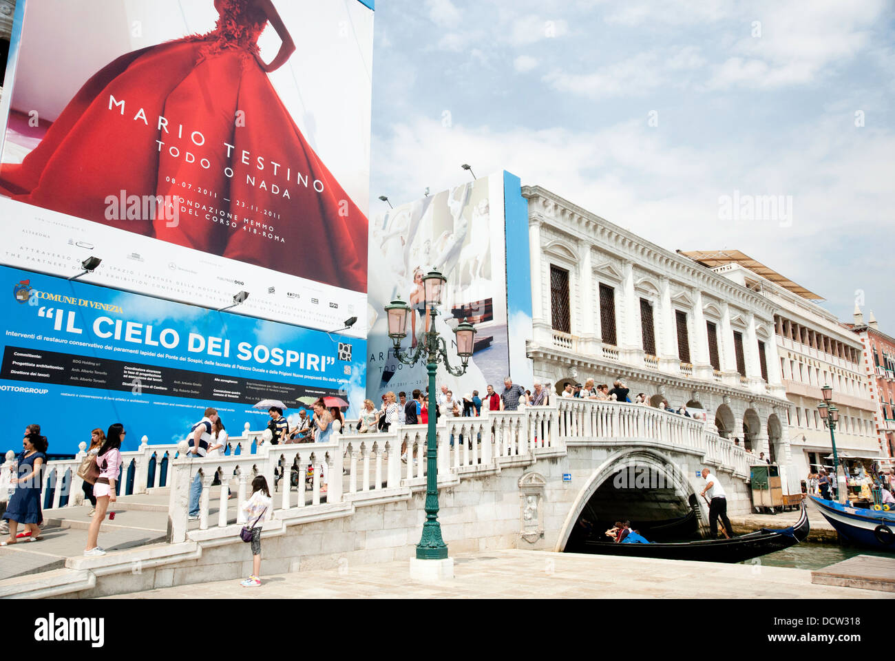 Des foules de touristes walking over bridge à côté de Palais des Doges, Venise, avec des gondoles. Banque D'Images