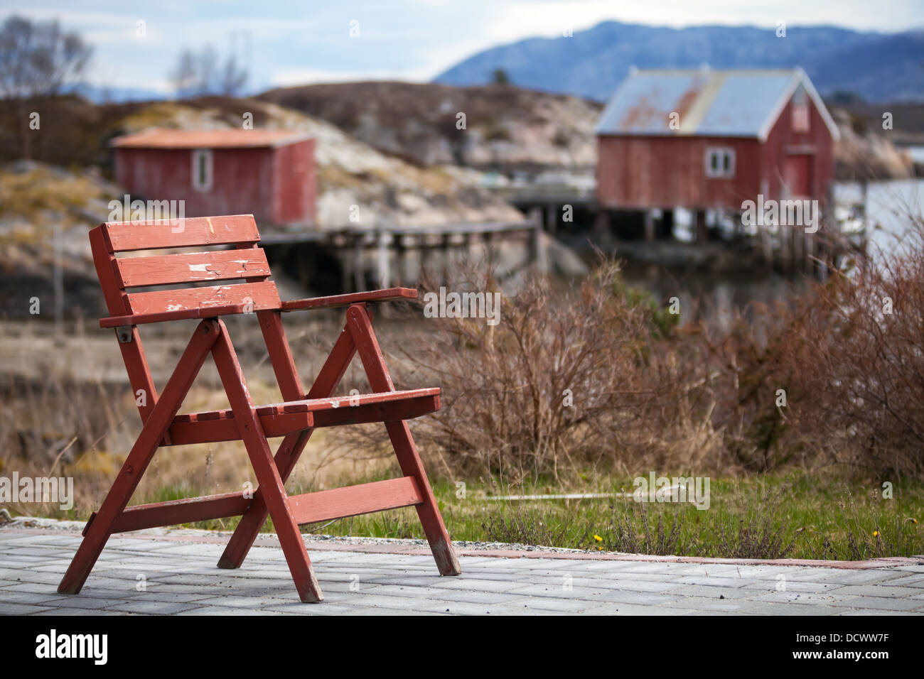 Chaise en bois rouge dans les petits village norvégien sur la côte de la mer Banque D'Images