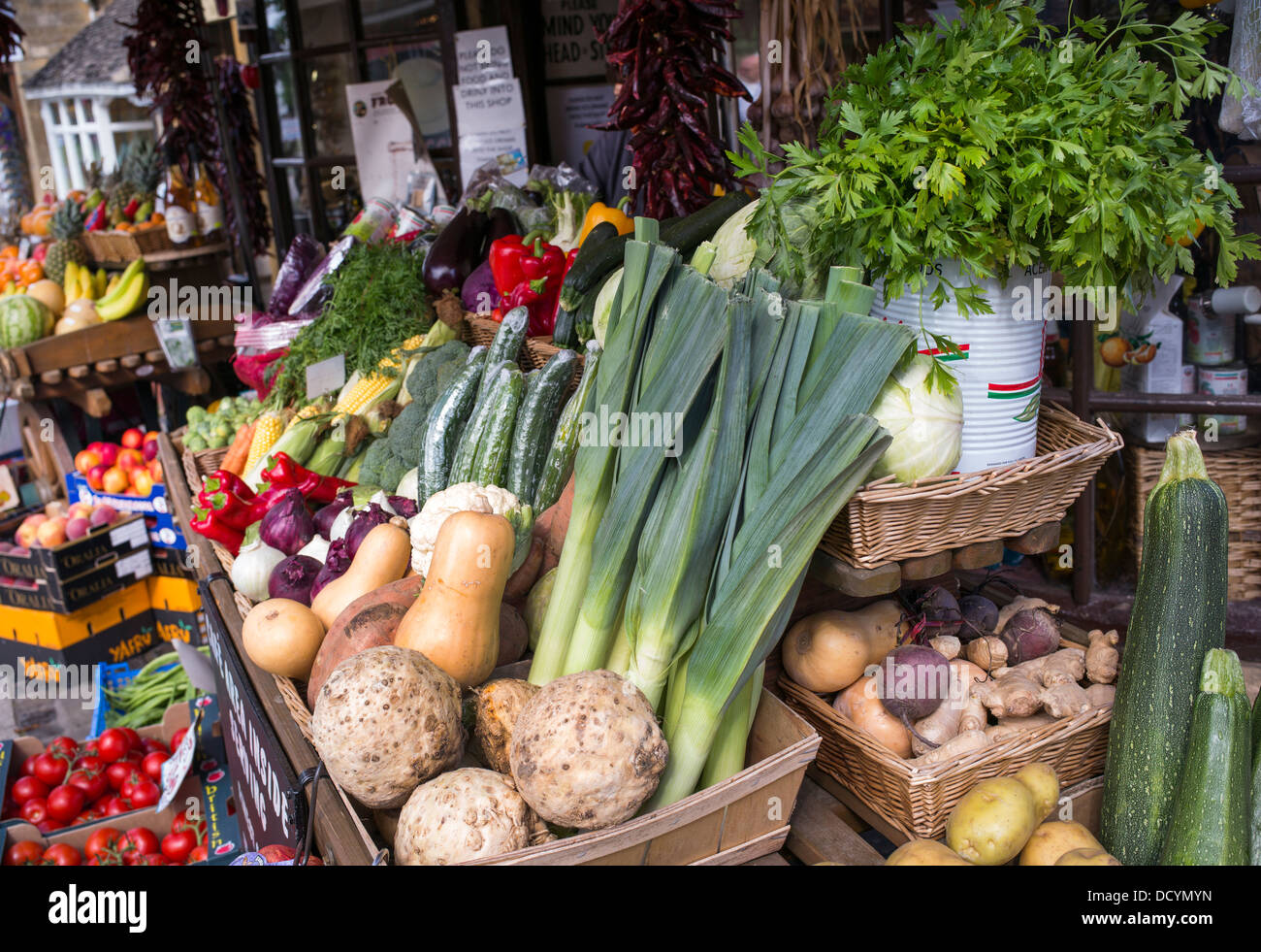 Les charrettes de fruits et légumes à l'extérieur de la boutique charcuterie, Broadway, Cotswolds, Worcestershire, Angleterre. Banque D'Images