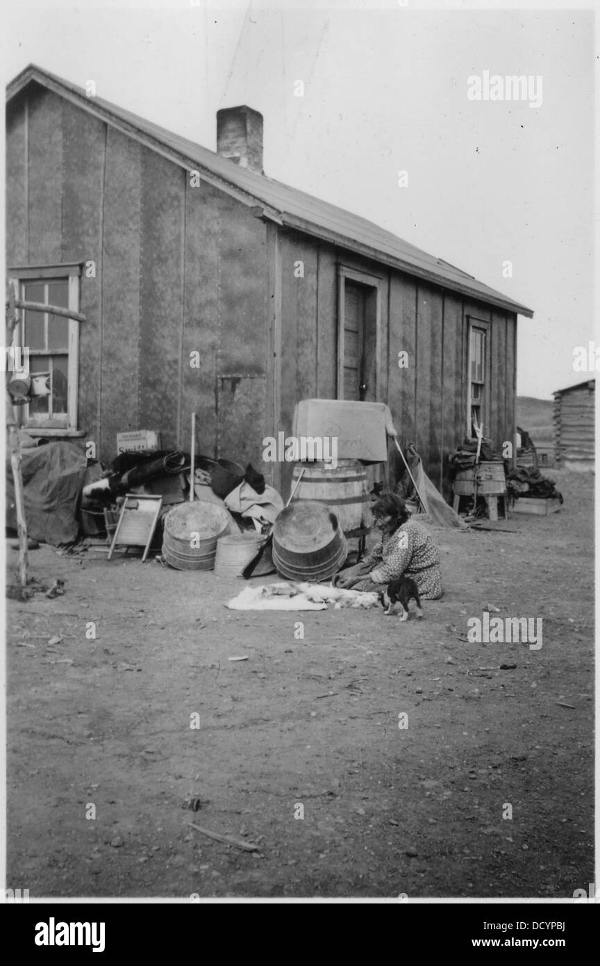 MRS Ray Eagle habille un lapin à l'extérieur de sa maison, mettant en valeur la vie rurale et les pratiques traditionnelles en matière de soins aux animaux. Banque D'Images