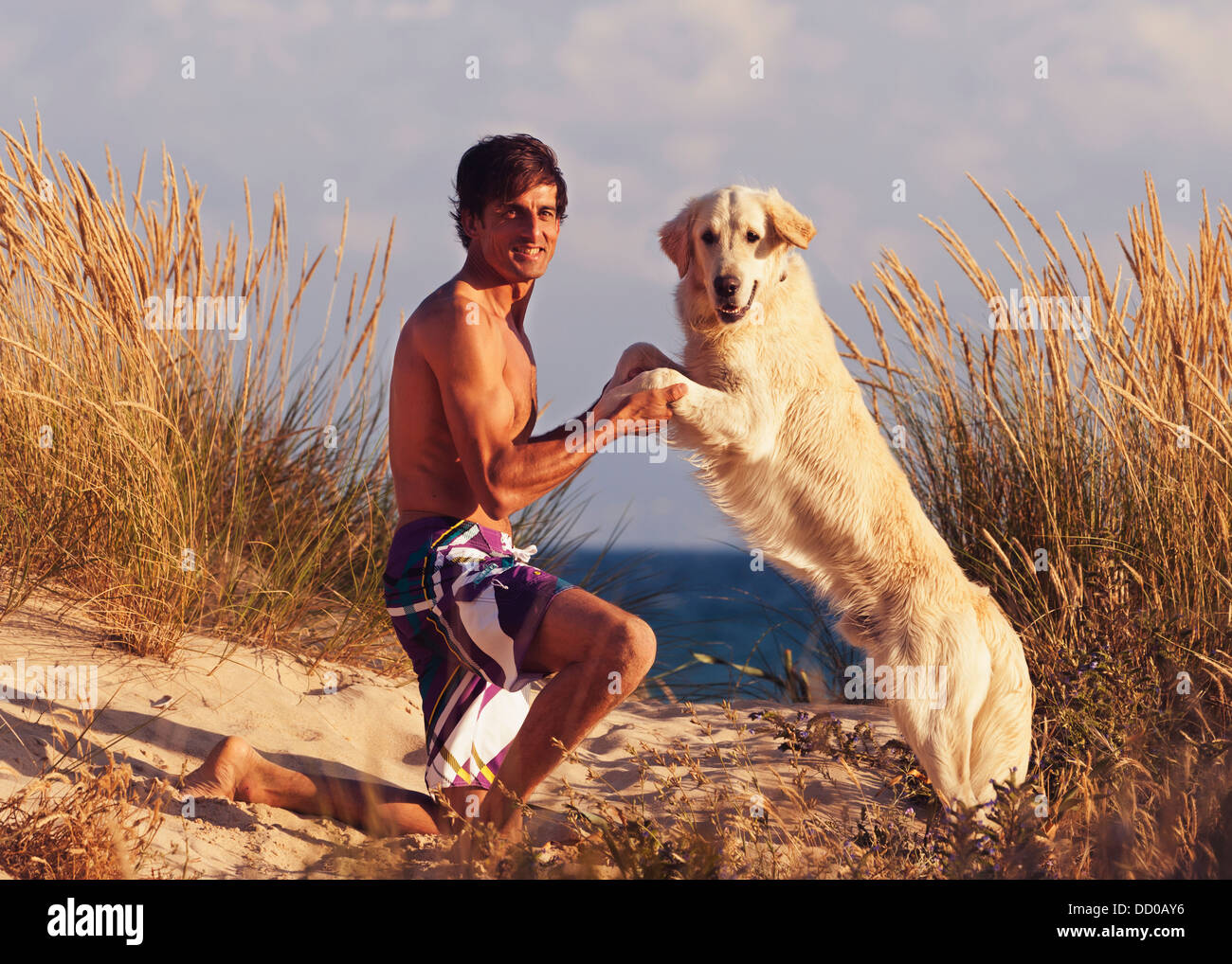 Un homme avec son Golden Retriever sur la plage de Los Lances, Tarifa, Cadix, Andalousie, Espagne Banque D'Images