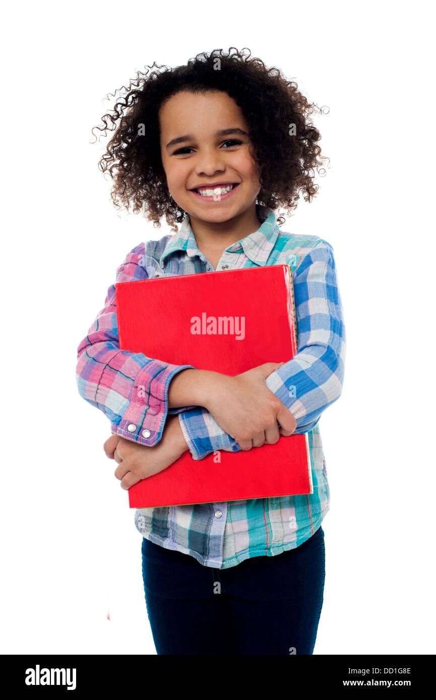 Smiling pretty school kid embrassant un ordinateur portable. Banque D'Images