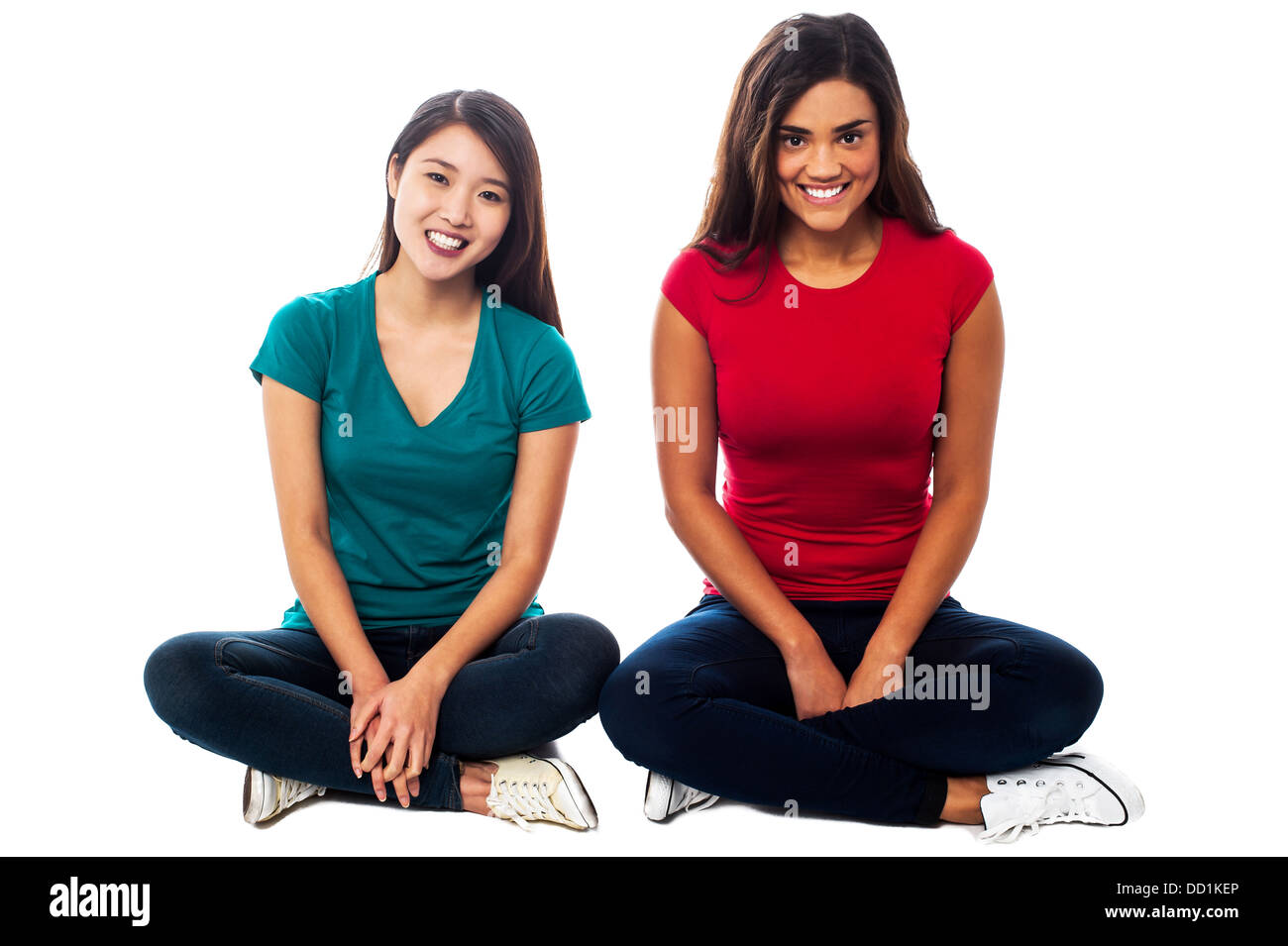 Deux jeunes filles assise sur le sol, les jambes croisées Banque D'Images