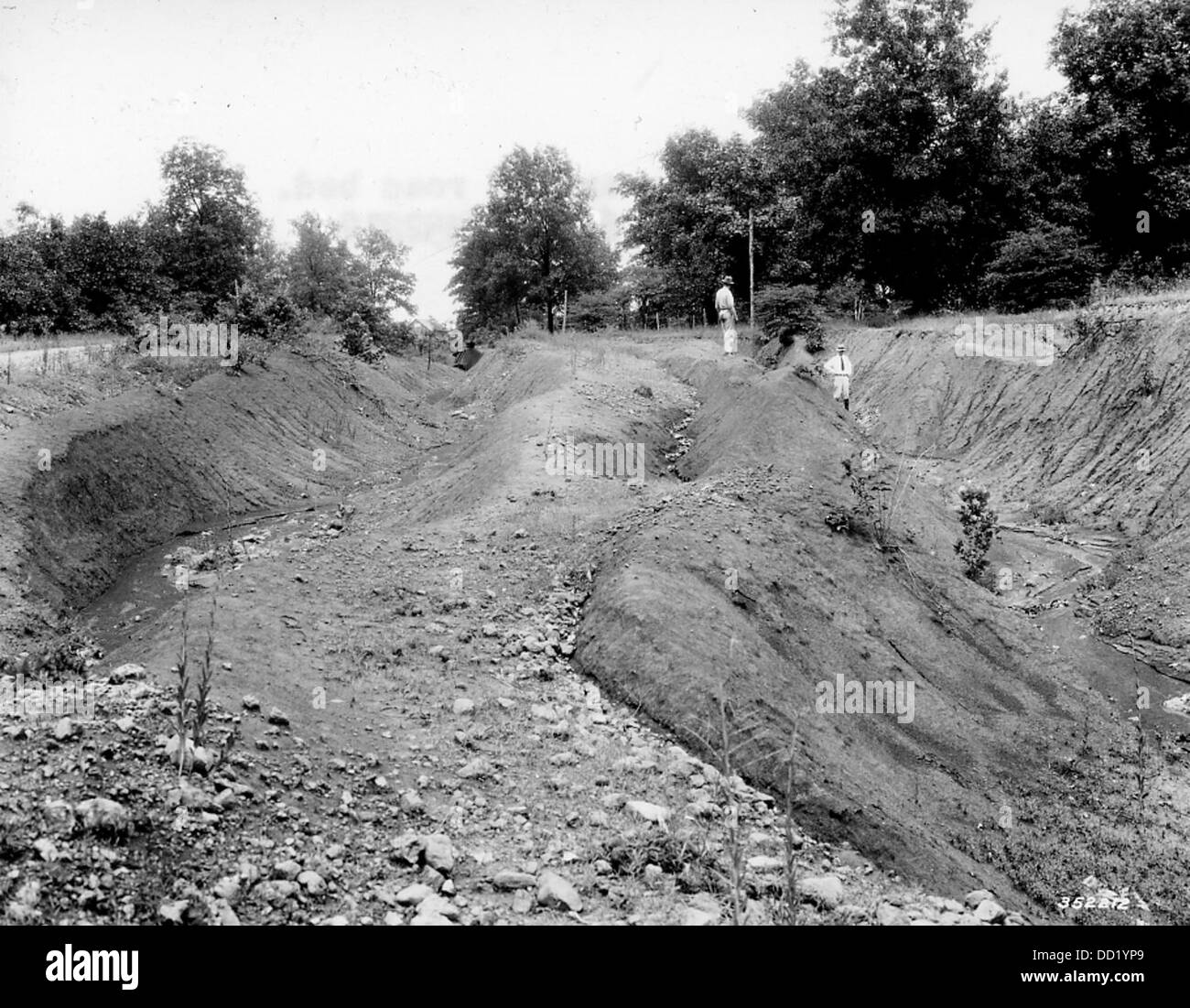 Érosion survenant à partir d'un ancien lit de route, montrant l'usure progressive du sol et de la roche due à l'eau et à des facteurs environnementaux. Cette image illustre le processus continu d’érosion dans un paysage touché par l’infrastructure humaine. Banque D'Images
