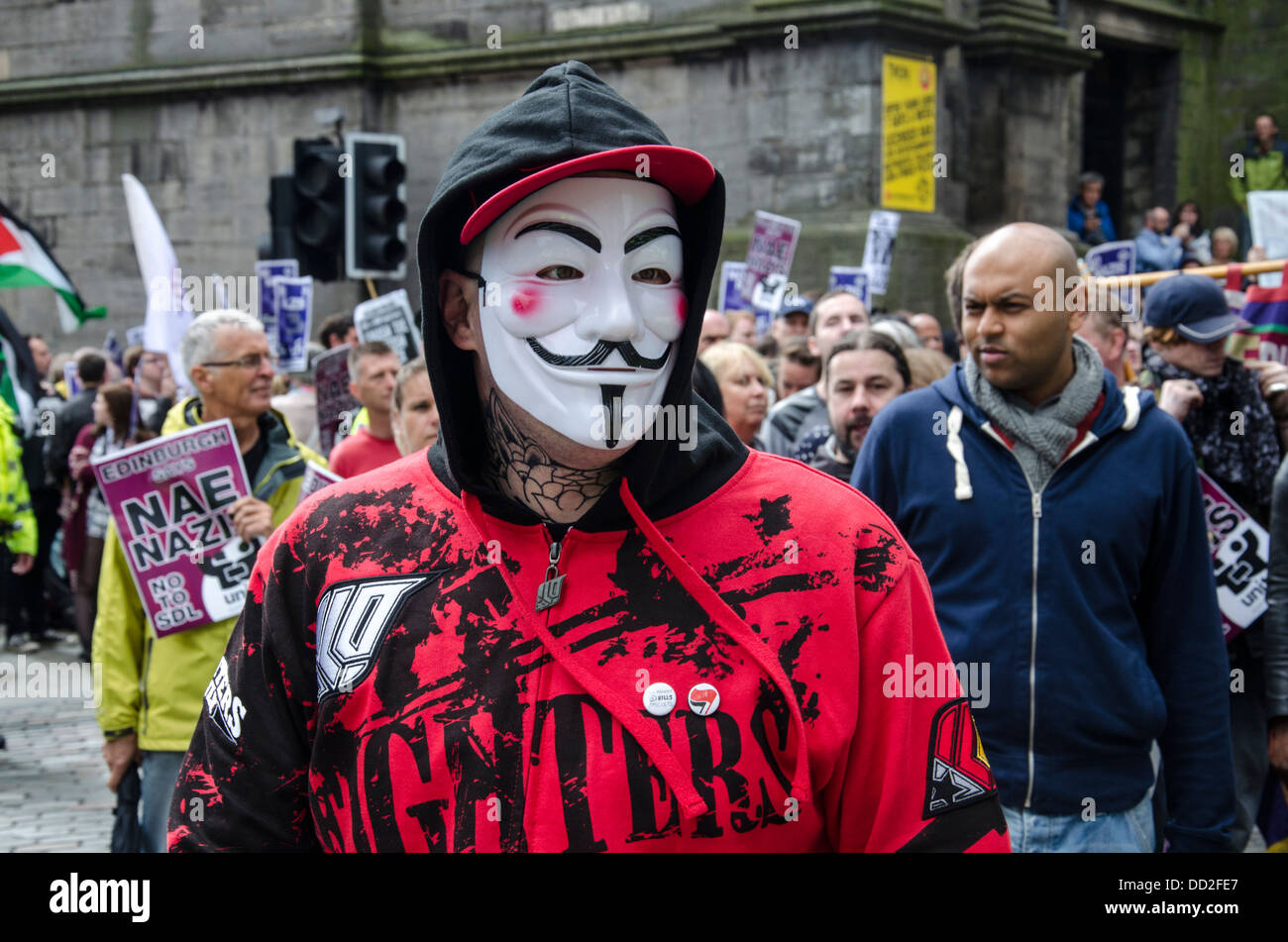 Manifestant anti-fasciste portant un masque anonyme dans la vieille ville d'Édimbourg. Banque D'Images
