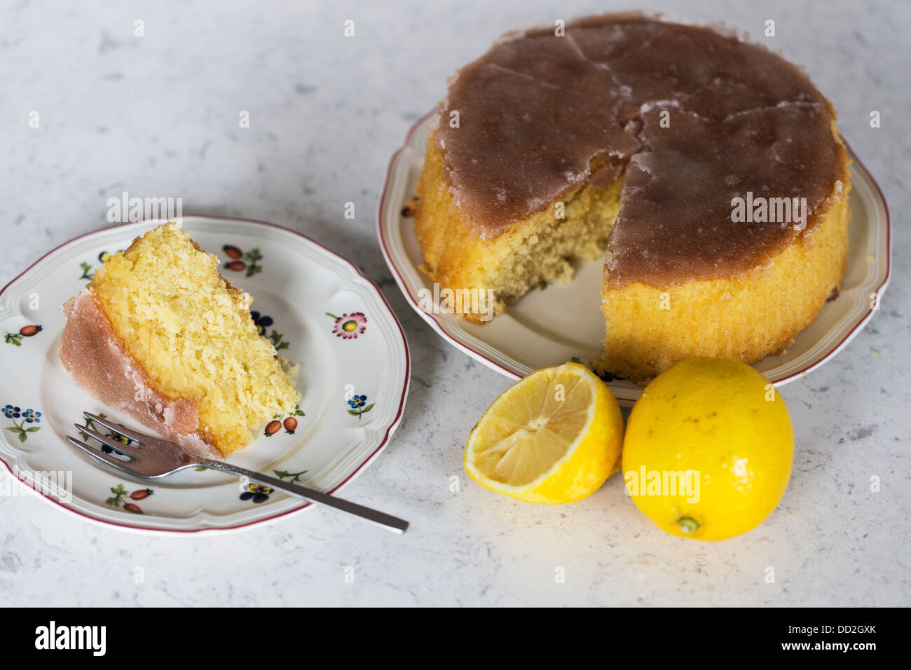 Accueil Citron cuit avec du sucre glace au chocolat glace haut, avec une coupe des coupes, plaques à motifs de fleurs, des gâteaux fourchette et deux citrons Banque D'Images