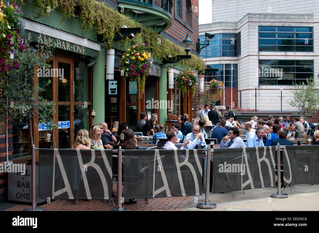 Les gens assis devant un bar de Brindley Place, Birmingham, UK Banque D'Images