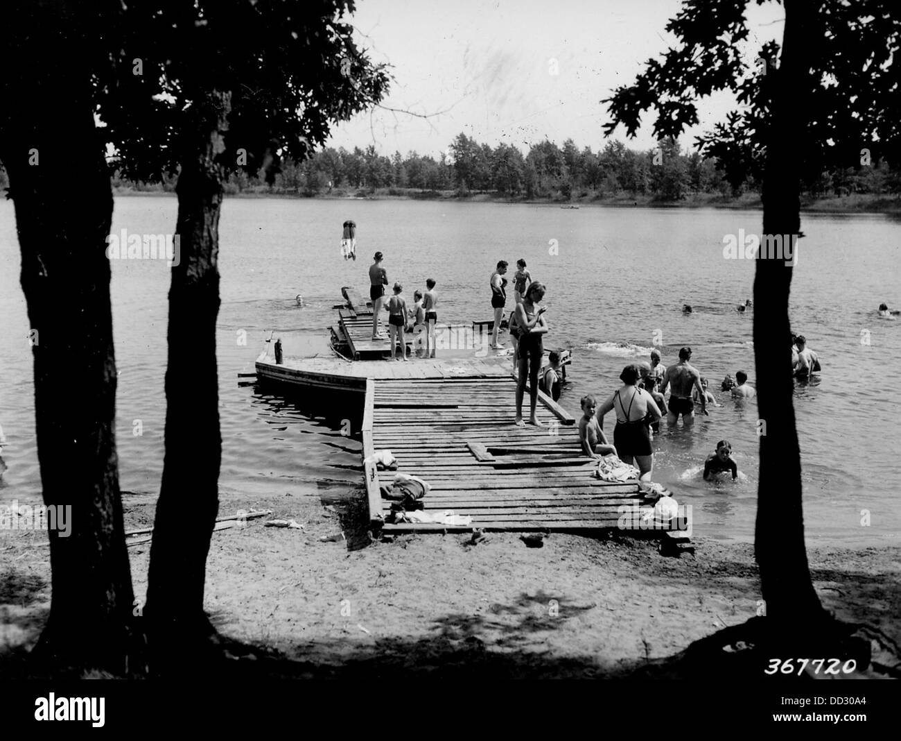 Une photographie montrant des gens nageant au lac Crystal à Wellston, Michigan. L'image capture une activité récréative populaire dans ce lac pittoresque, connu pour ses eaux claires et sa beauté naturelle. Banque D'Images