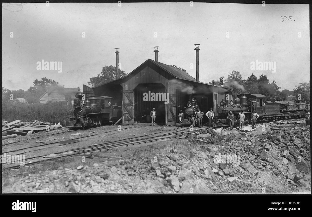 Cette photographie montre des travailleurs déchargeant des wagons-bennes de la Western W.S. Company à Guard Lock, un emplacement le long d'un canal d'alimentation. La scène met en lumière les activités industrielles du début du XXe siècle liées au transport par voie navigable. Banque D'Images