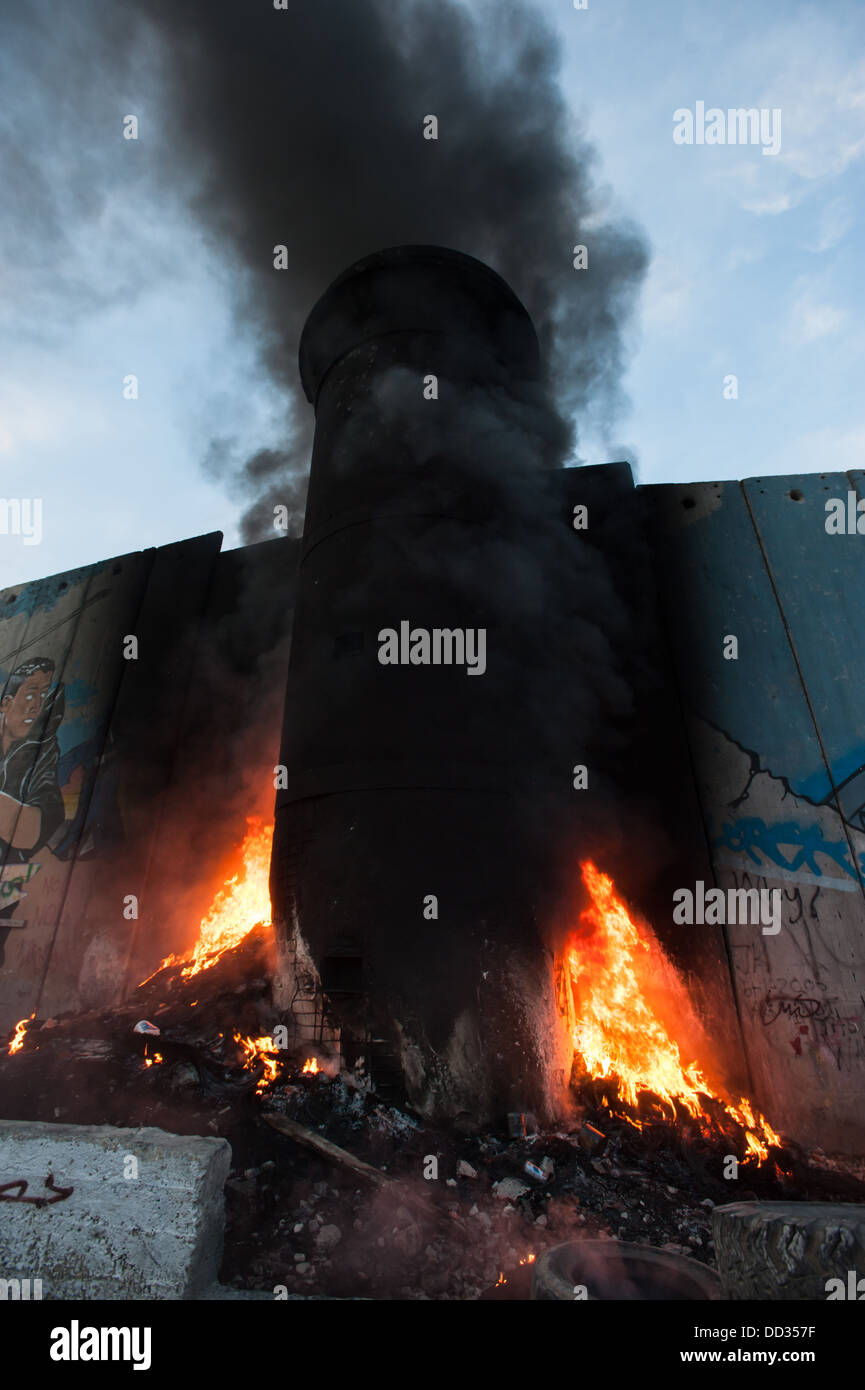 Un feu brûle à une tour dans le mur de séparation israélien suite aux affrontements dans le camp de réfugiés de Aida dans la ville cisjordanienne de Bethléem Banque D'Images