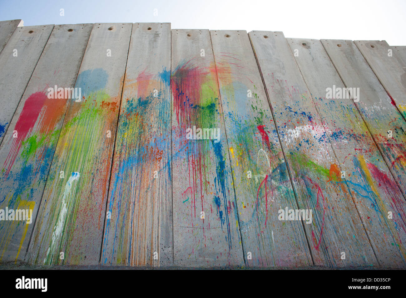 Un arc-en-ciel de couleurs de peinture éclaboussé couvre le mur de séparation israélien dans la ville palestinienne d'Abu Dis. Banque D'Images