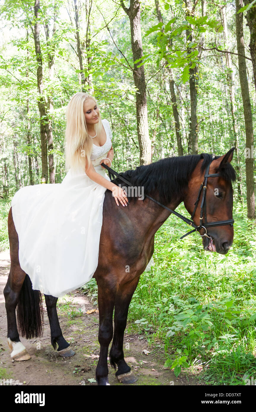Belle Mariée à cheval dans la forêt Banque D'Images