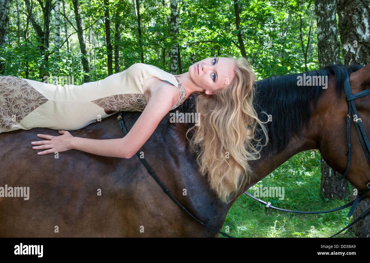 Jeune jolie fille pose à cheval dans la forêt Banque D'Images