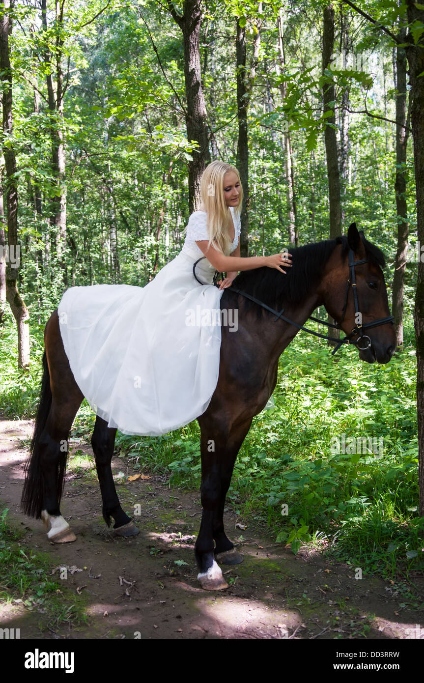 Belle Mariée à cheval dans la forêt Banque D'Images