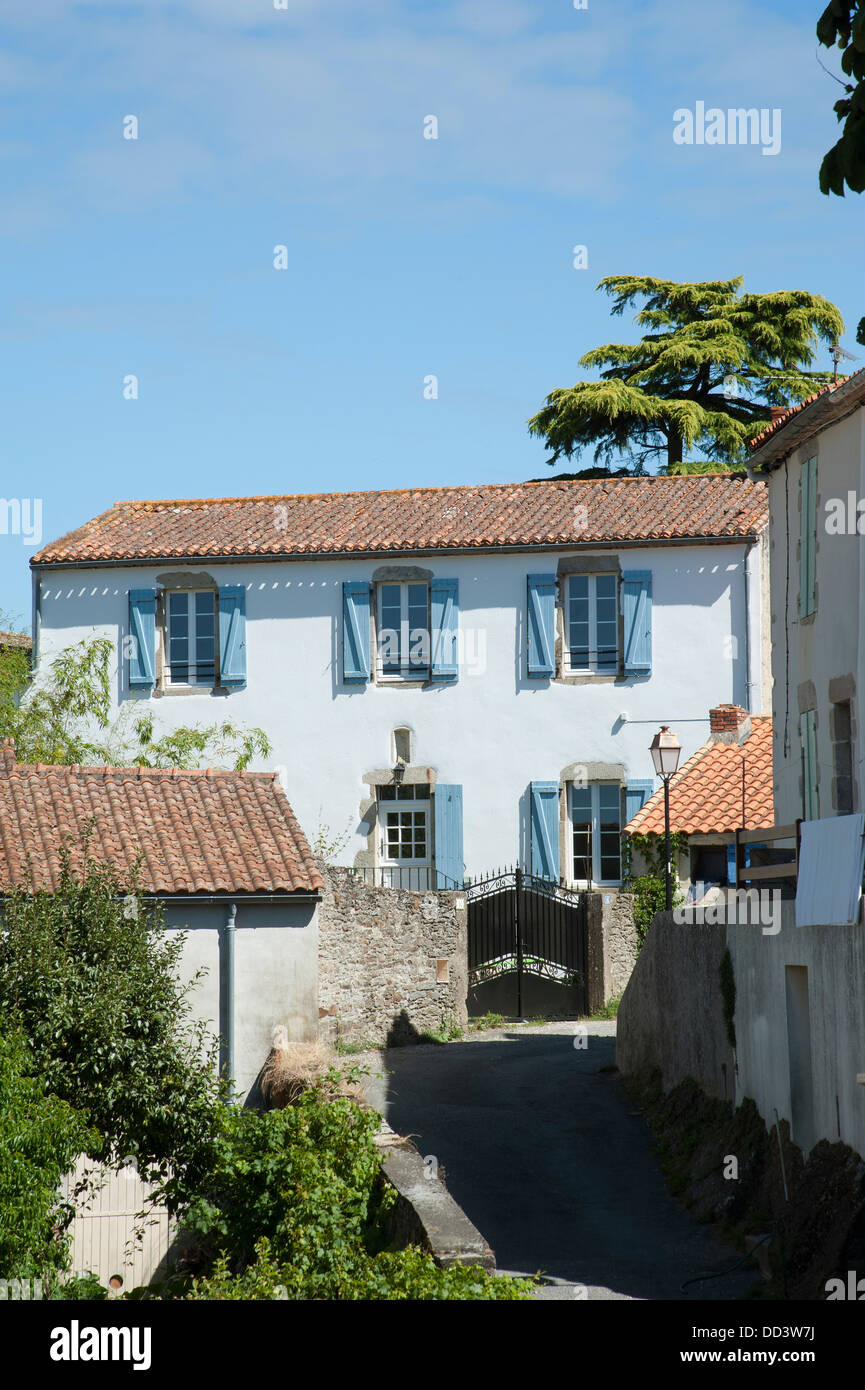 Propriété de campagne typique avec toit de tuiles et volets bleus sur les fenêtres Banque D'Images