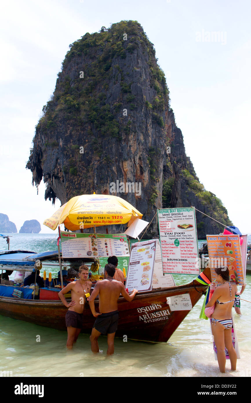 Les gens d'acheter de la nourriture dans un restaurant bateau ancré sur la plage de Hat Phra Nang Railay dans l'île heureuse avec en arrière-plan. Banque D'Images