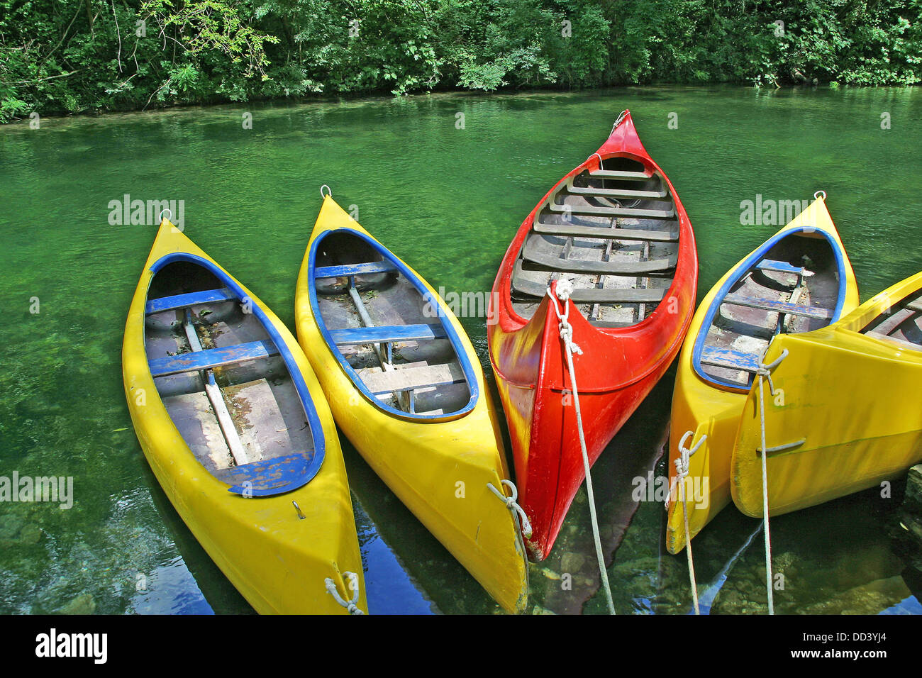 Jaune et rouge en plastique vide canots dans vert turquoise river Banque D'Images