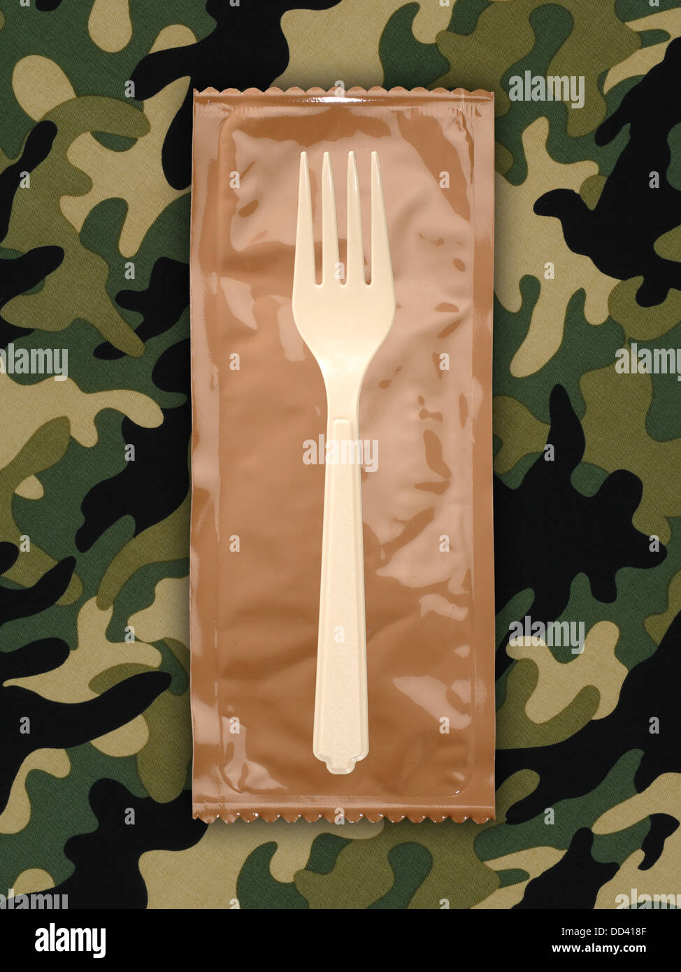 Des rations alimentaires militaires ou MRE repas prêt à manger sur un fond camouflé. Ouvrir les paquets avec des ustensiles en plastique. Banque D'Images