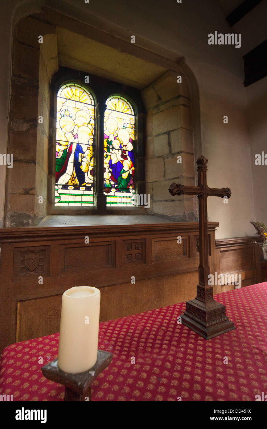 Vitrail et une table avec une croix à l'intérieur d'une église ; Northumberland, England Banque D'Images