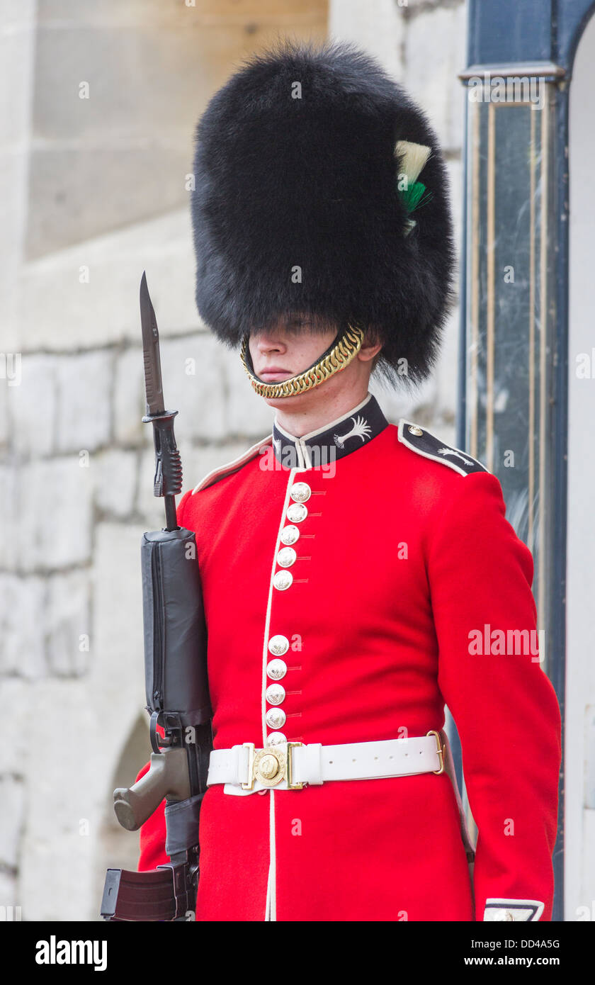 Soldat dans la garde de la Reine au château de Windsor, en Angleterre, avec l'uniforme rouge et noir traditionnel cap bearskin ou busby Banque D'Images