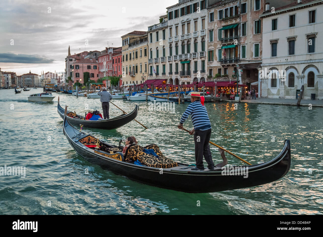 Gondoliers voile avec les touristes sur le Grand Canal à Venise au coucher du soleil Banque D'Images