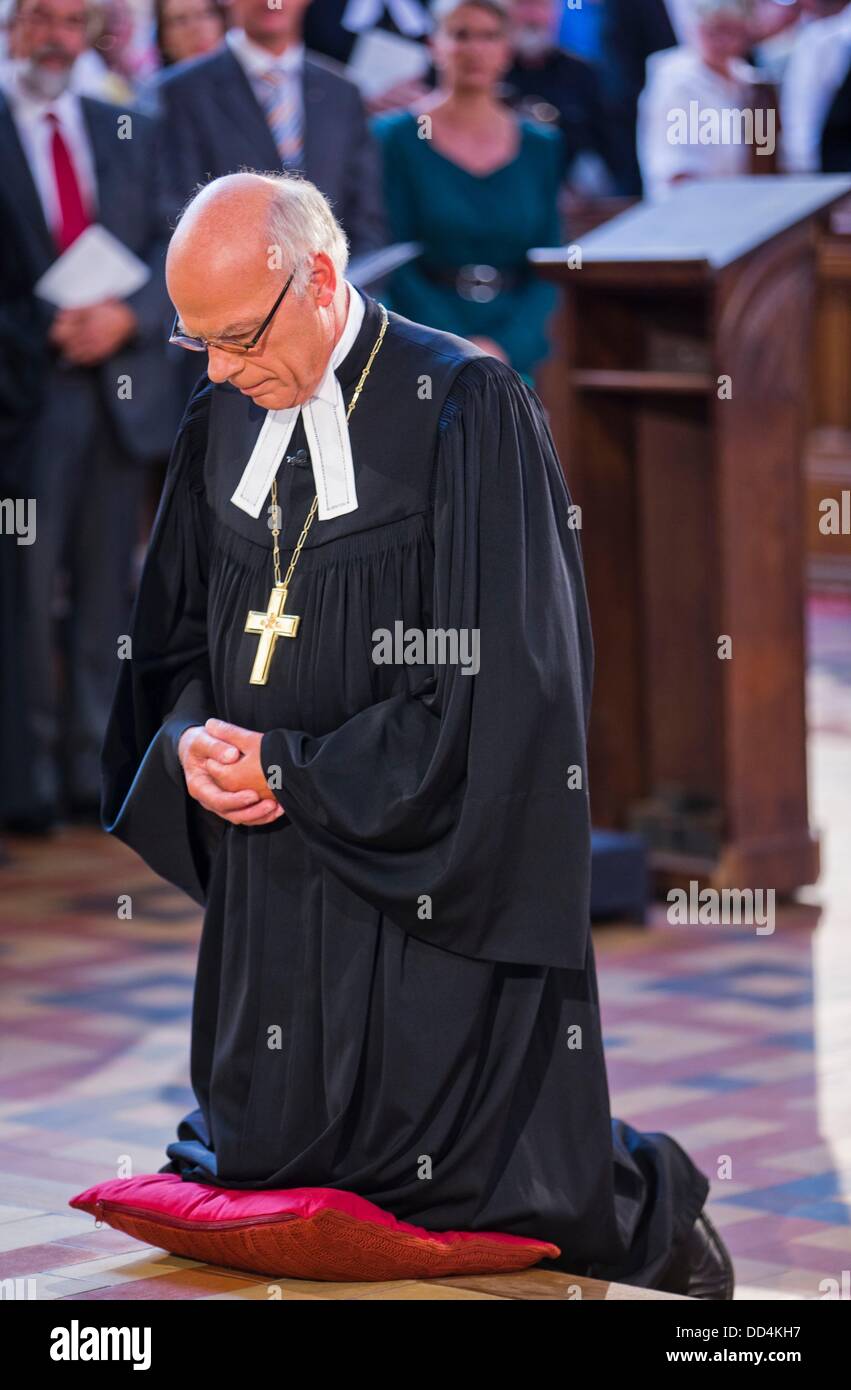 Le premier évêque de l'état de l'Église évangélique luthérienne de l'Allemagne du Nord, connue sous le nom de North Church et fondée en 2012, Gerhard Ulrich, s'agenouille devant l'autel au cours de son introduction solennelle au pouvoir dans la cathédrale de Schwerin, Allemagne, 25 août 2013. 750 personnes ont été invités à l'événement. Photo : JENS BUETTNER Banque D'Images