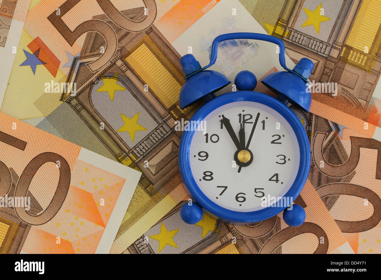 Le temps est argent concept, horloge miniature sur les billets Banque D'Images