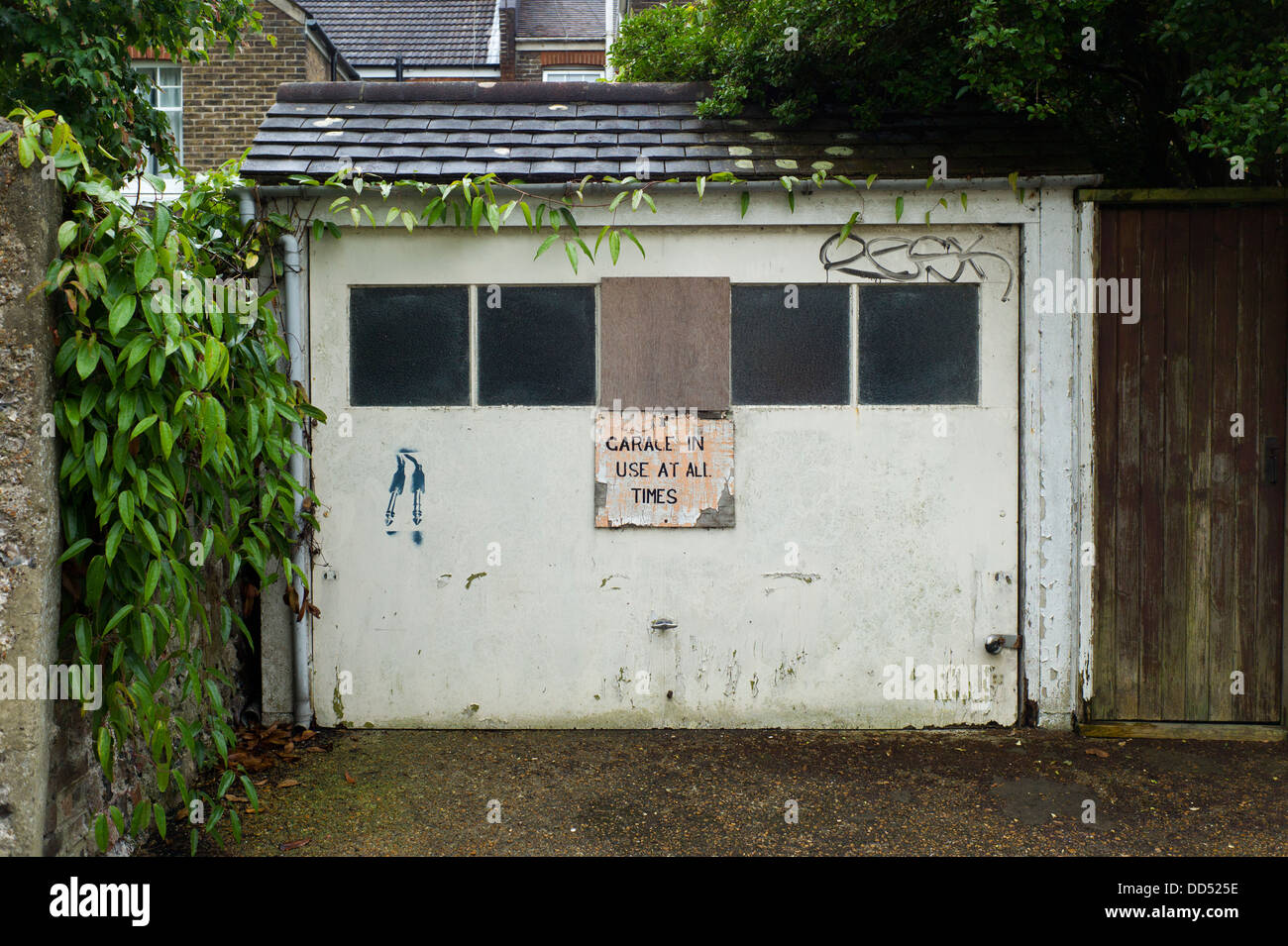 Vieille porte de garage et graffiti, Brighton, UK Banque D'Images